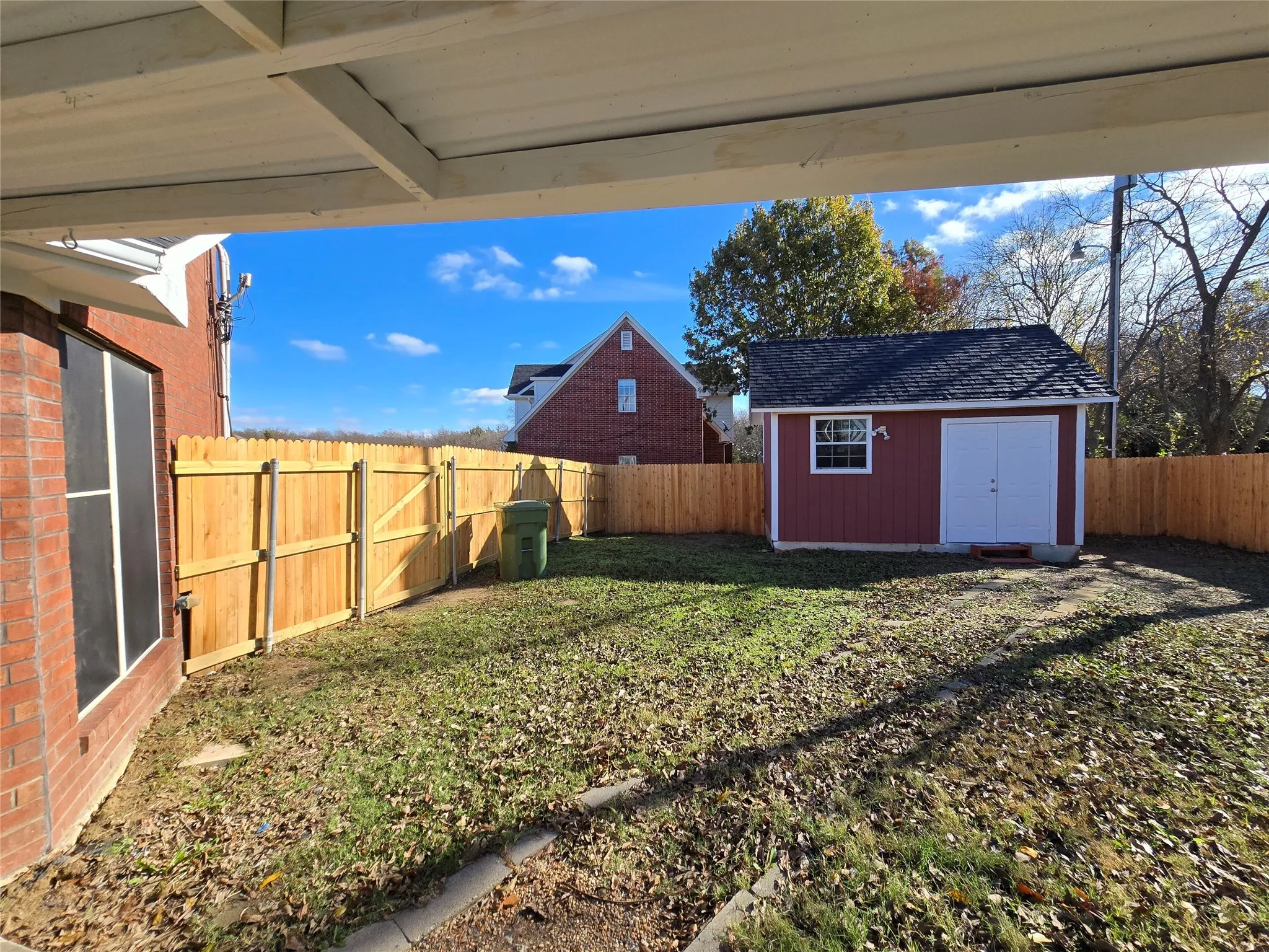 Fenced backyard with a storage unit