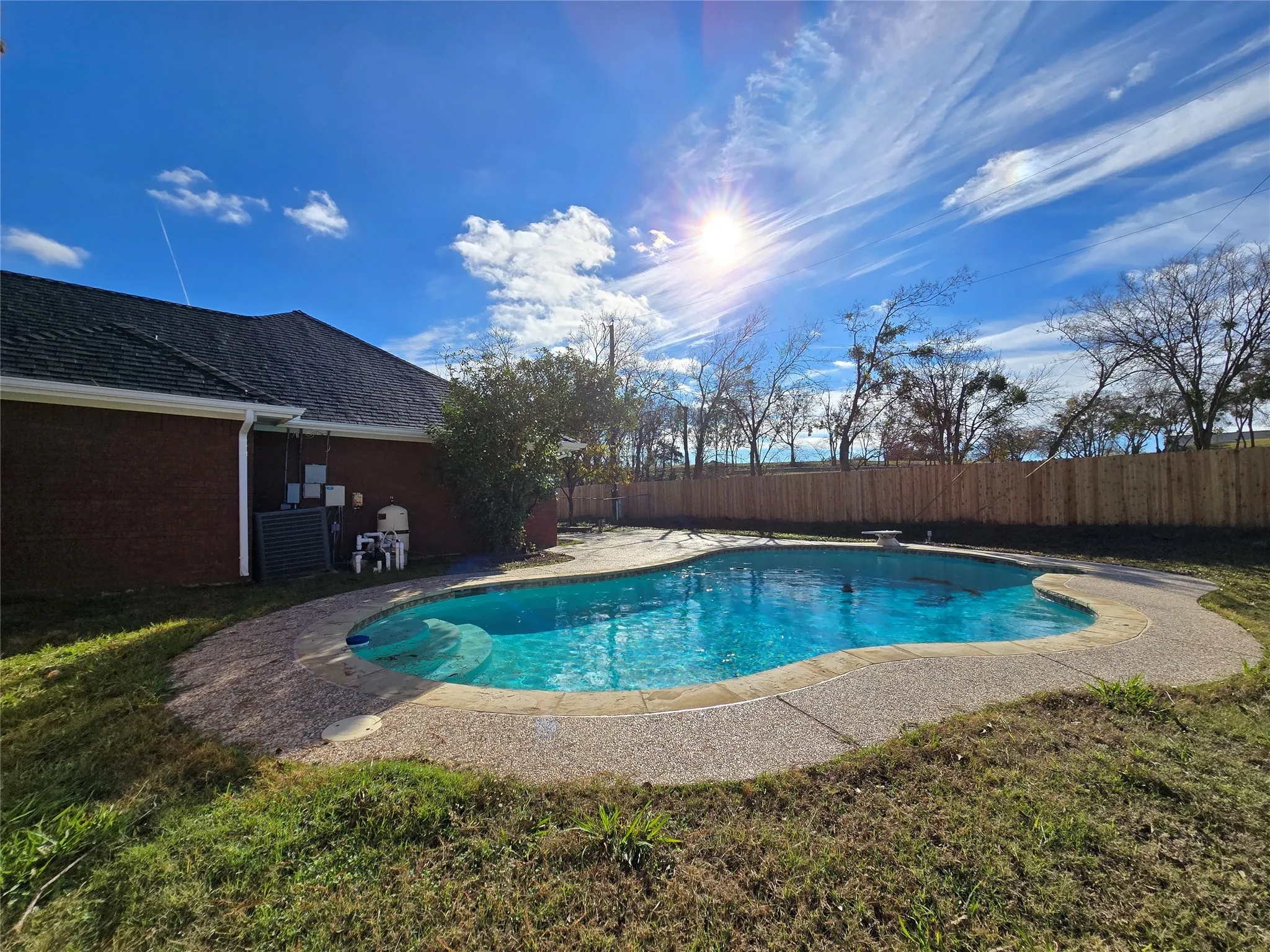 View of swimming pool featuring a fenced backyard, a patio area, and a diving board