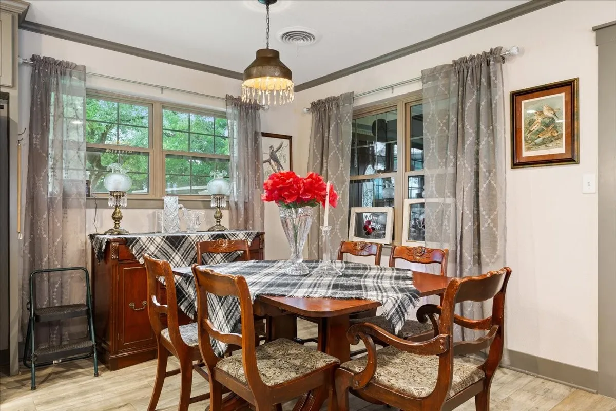 Dining space featuring ornamental molding and light wood-type flooring