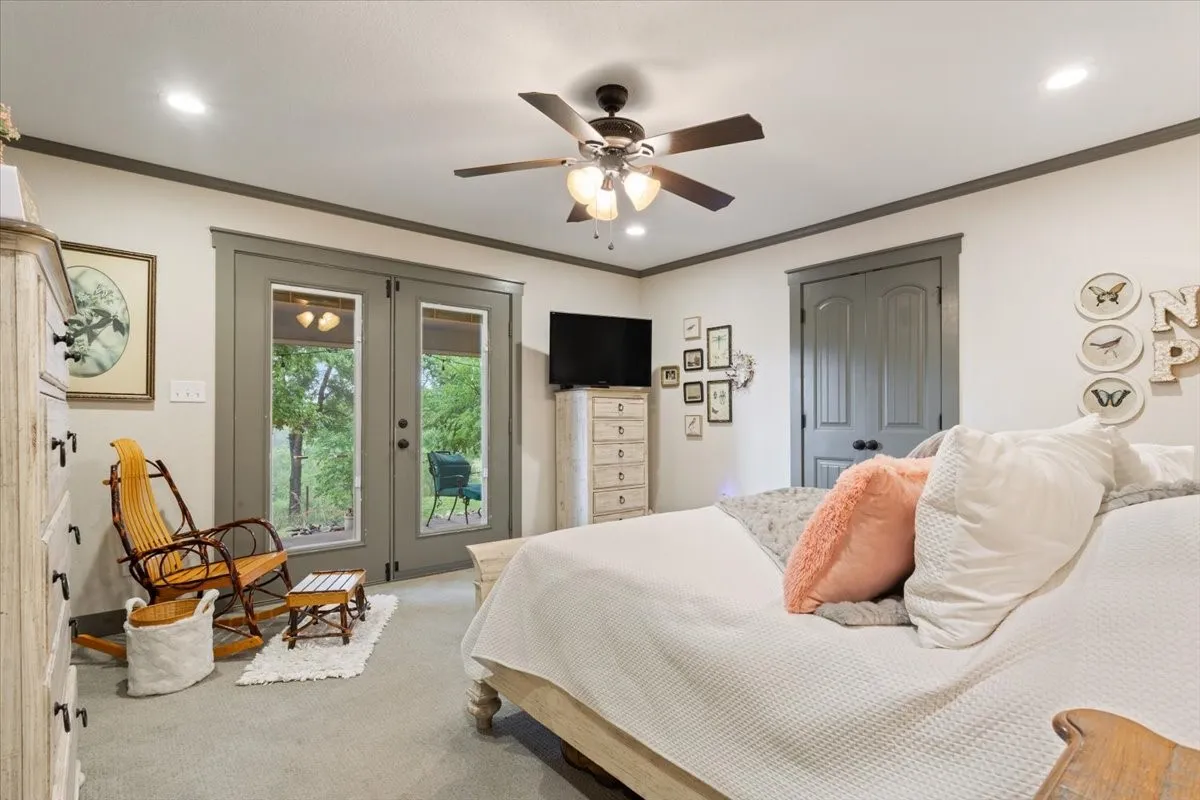 Bedroom with french doors, a closet, ceiling fan, crown molding, and carpet floors