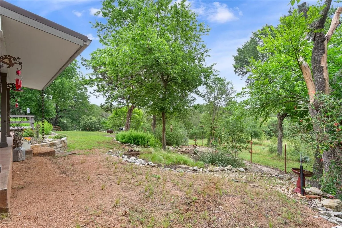 View of grassy yard featuring view of scattered trees