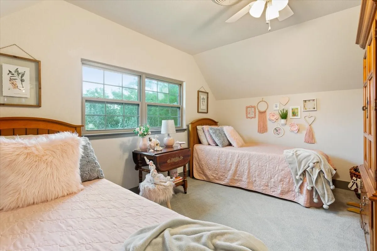 Bedroom featuring vaulted ceiling, carpet floors, and a ceiling fan