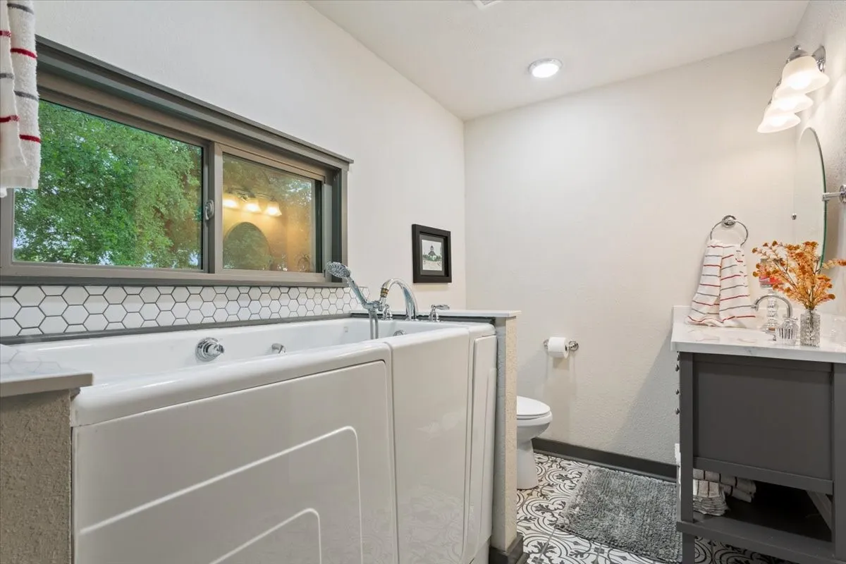 Full bathroom with vanity, a bath, and dark tile patterned flooring