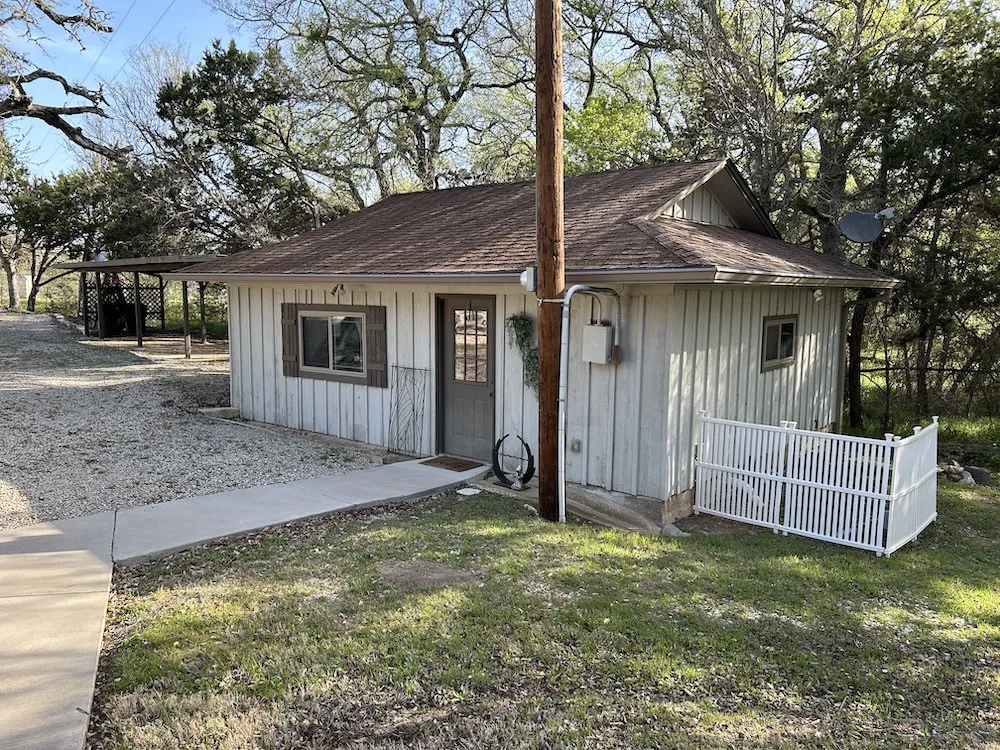 View of front of property featuring board and batten siding, a front lawn, and roof with shingles