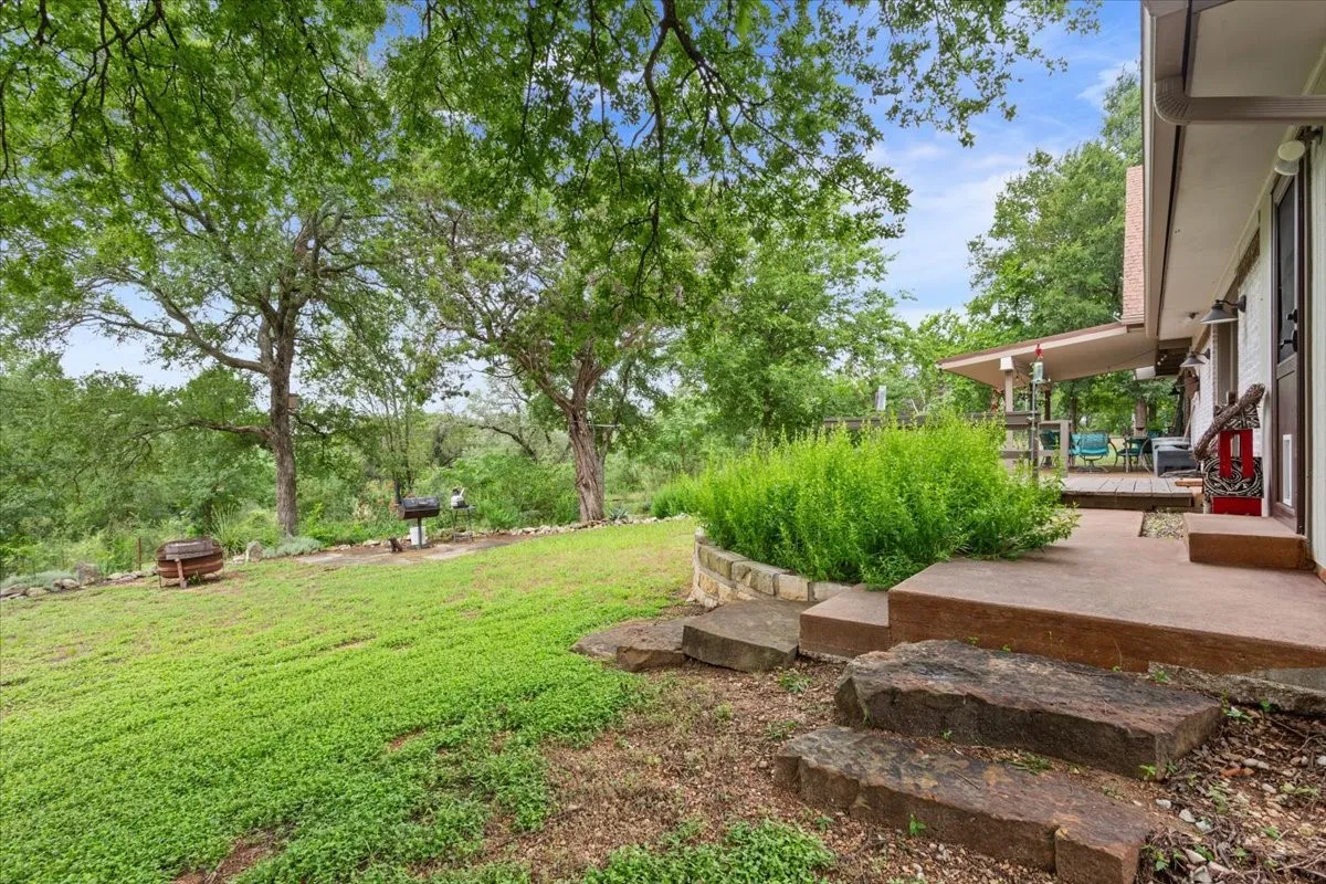 View of grassy yard with a wooden deck