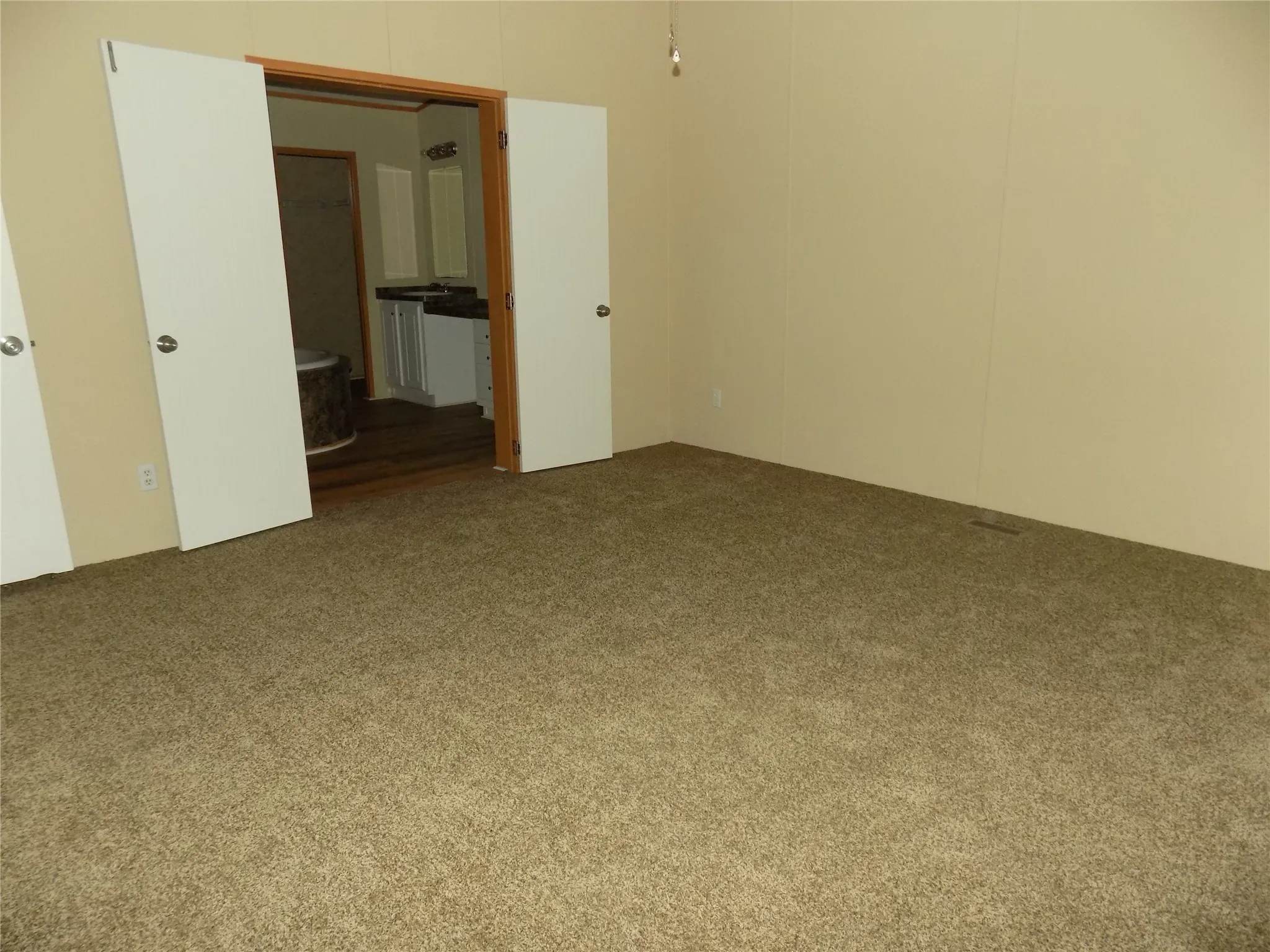 Primary bedroom with double doors to the ensuite bathroom.