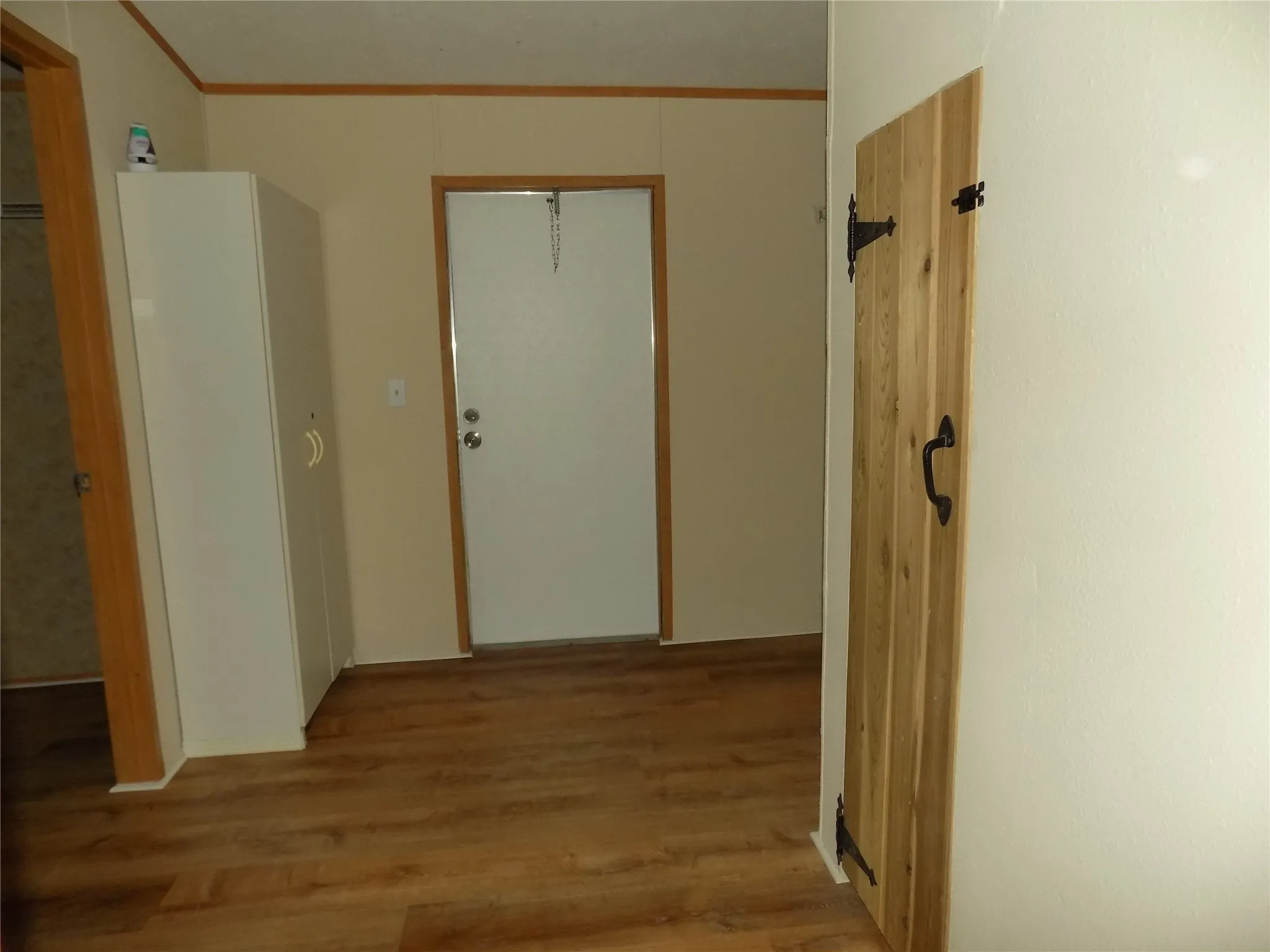 Spacious laundry room, notice door on left, it is a large extra walk-in closet; the cabinet to the left is extra, and the pine door hides a water heater.  To the right of the door straight back is the washer and dryer connections.  It is a great space.