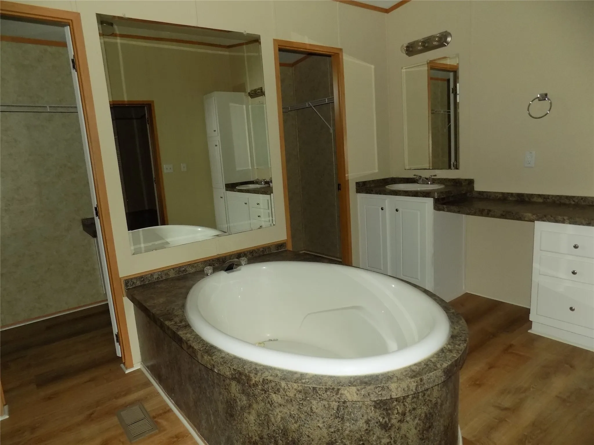 Wonderful garden tub with both walk-in closet doors showing.