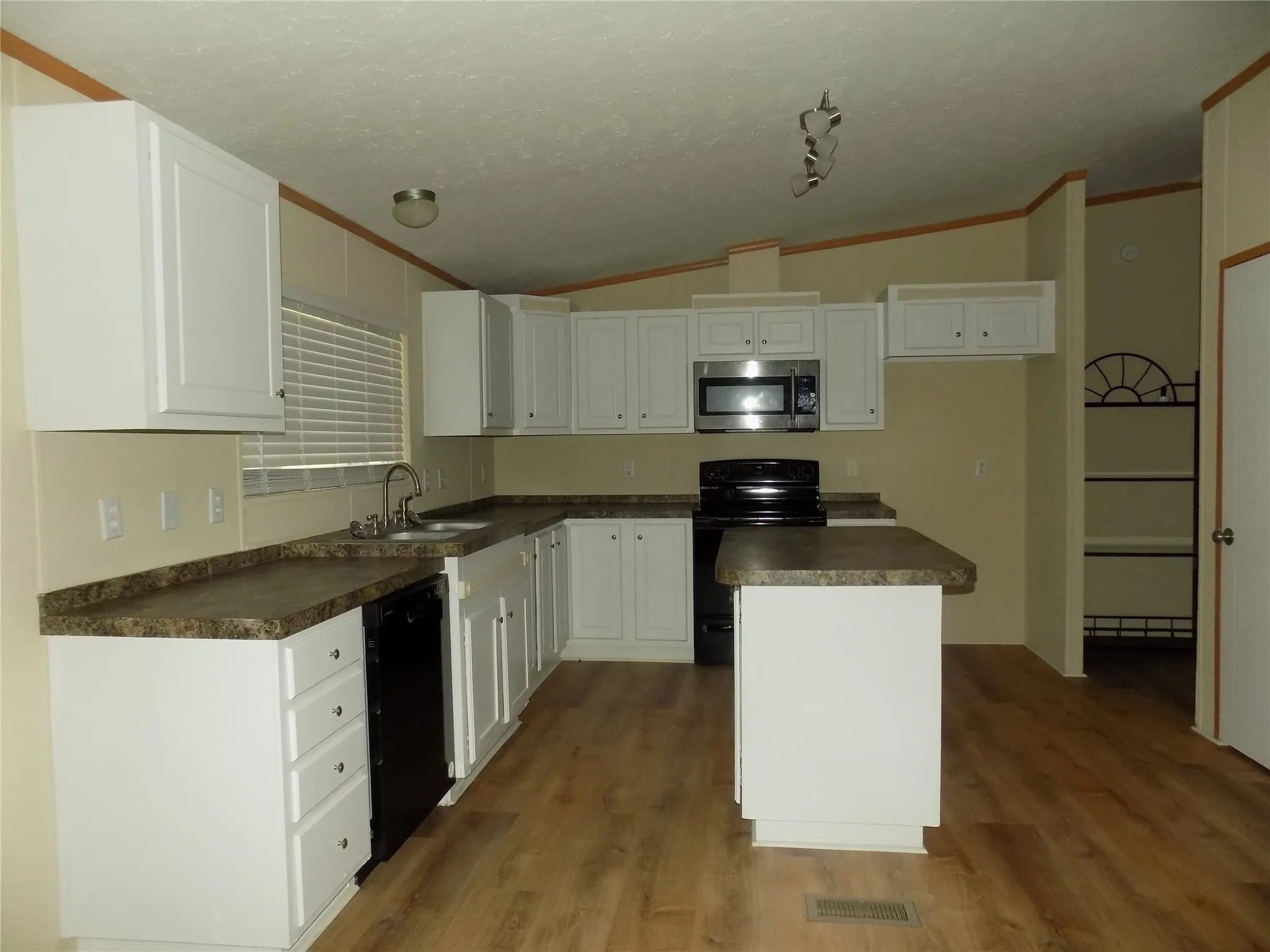 Wonderful kitchen space with kitchen island, electric stove and overhead microwave, dishwasher and window of the sink. Perfect!