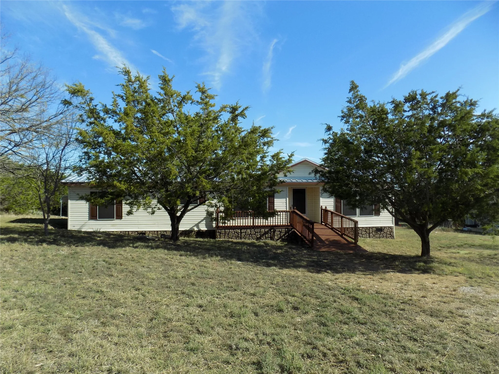 View of front of property featuring a front yard and large entry deck.