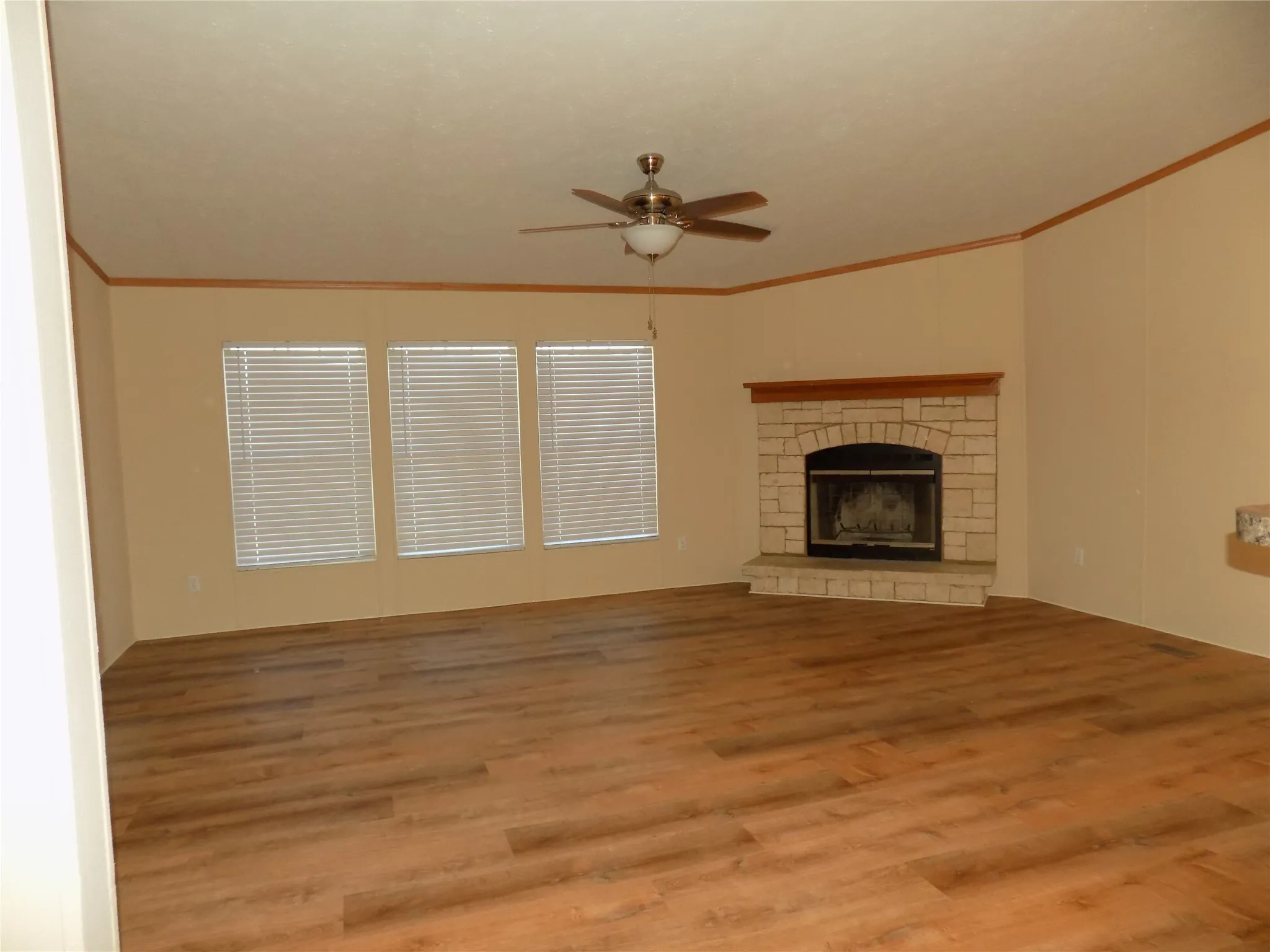 Spacious living room with warm, welcoming fireplace and windows to give you a light and bright room.