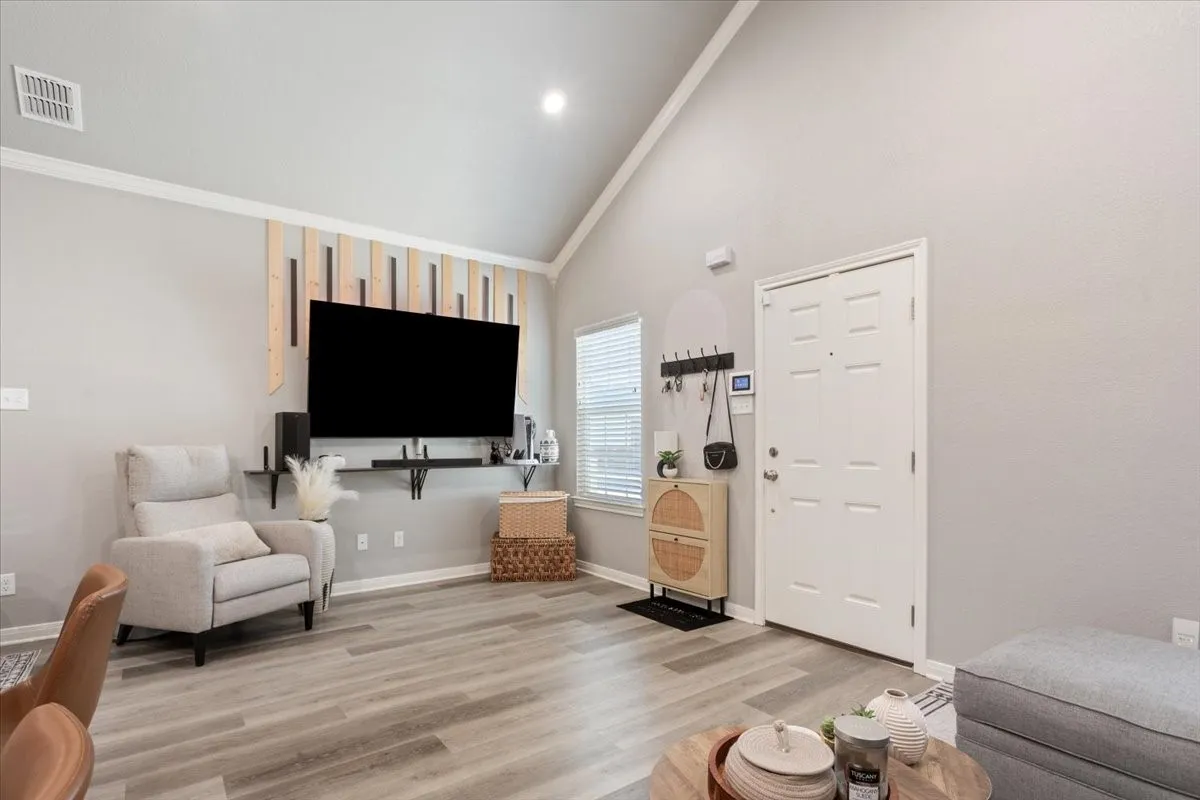 Living area with high vaulted ceiling and light wood-style flooring