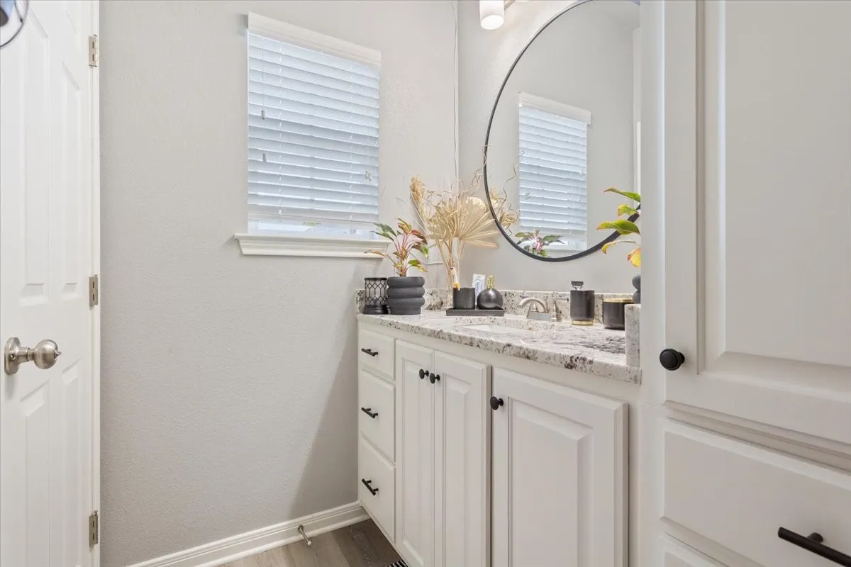 Bathroom featuring vanity, light wood-style floors, and a textured wall