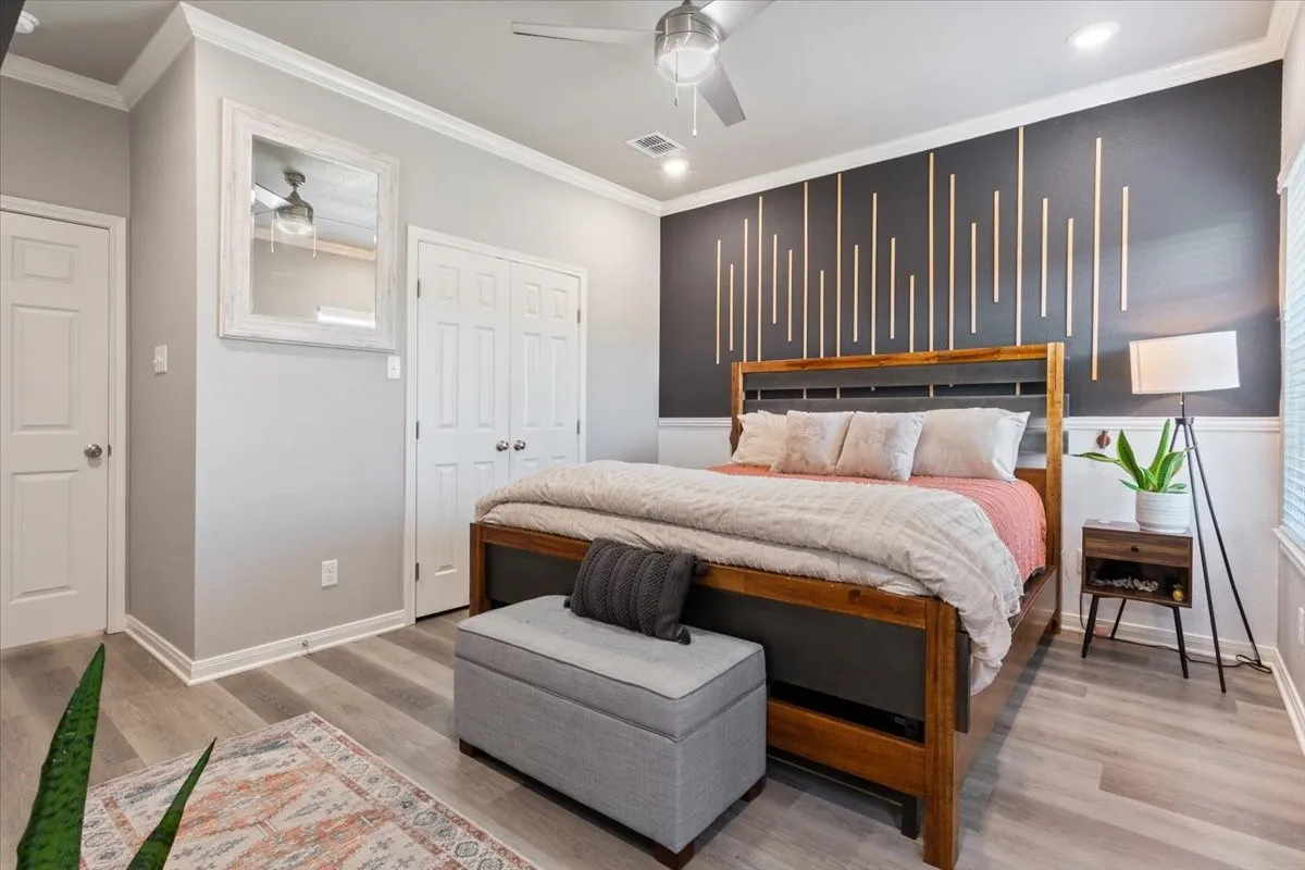 Bedroom with ornamental molding, light wood-type flooring, a ceiling fan, and recessed lighting