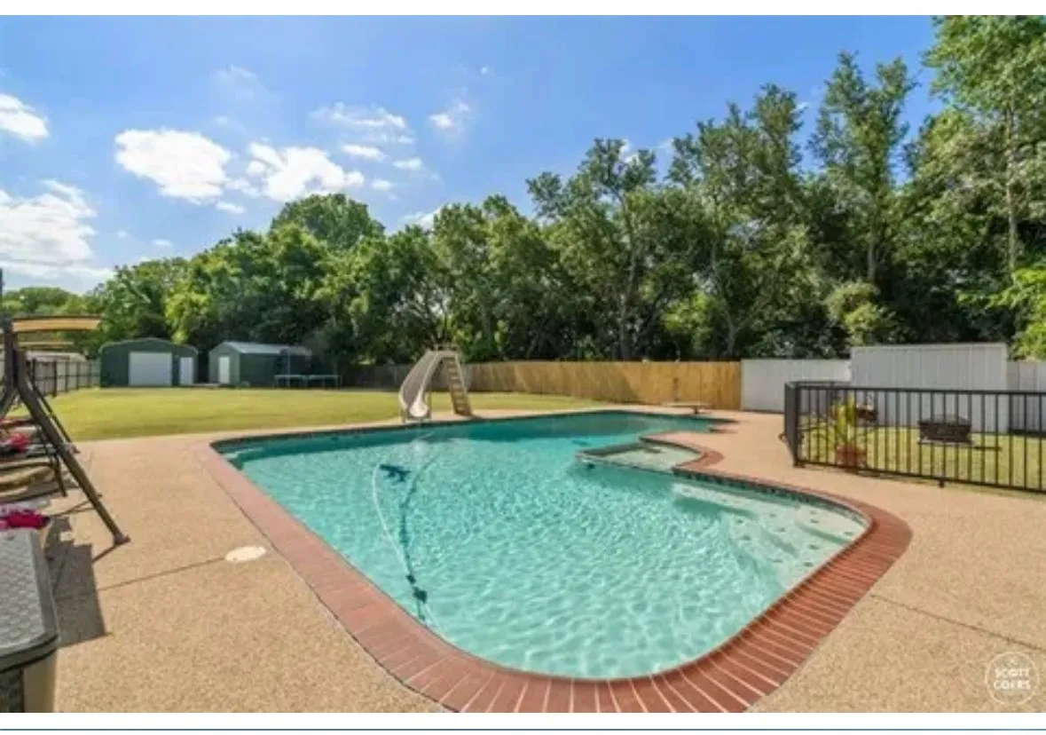 View of swimming pool with a water slide and a patio area
