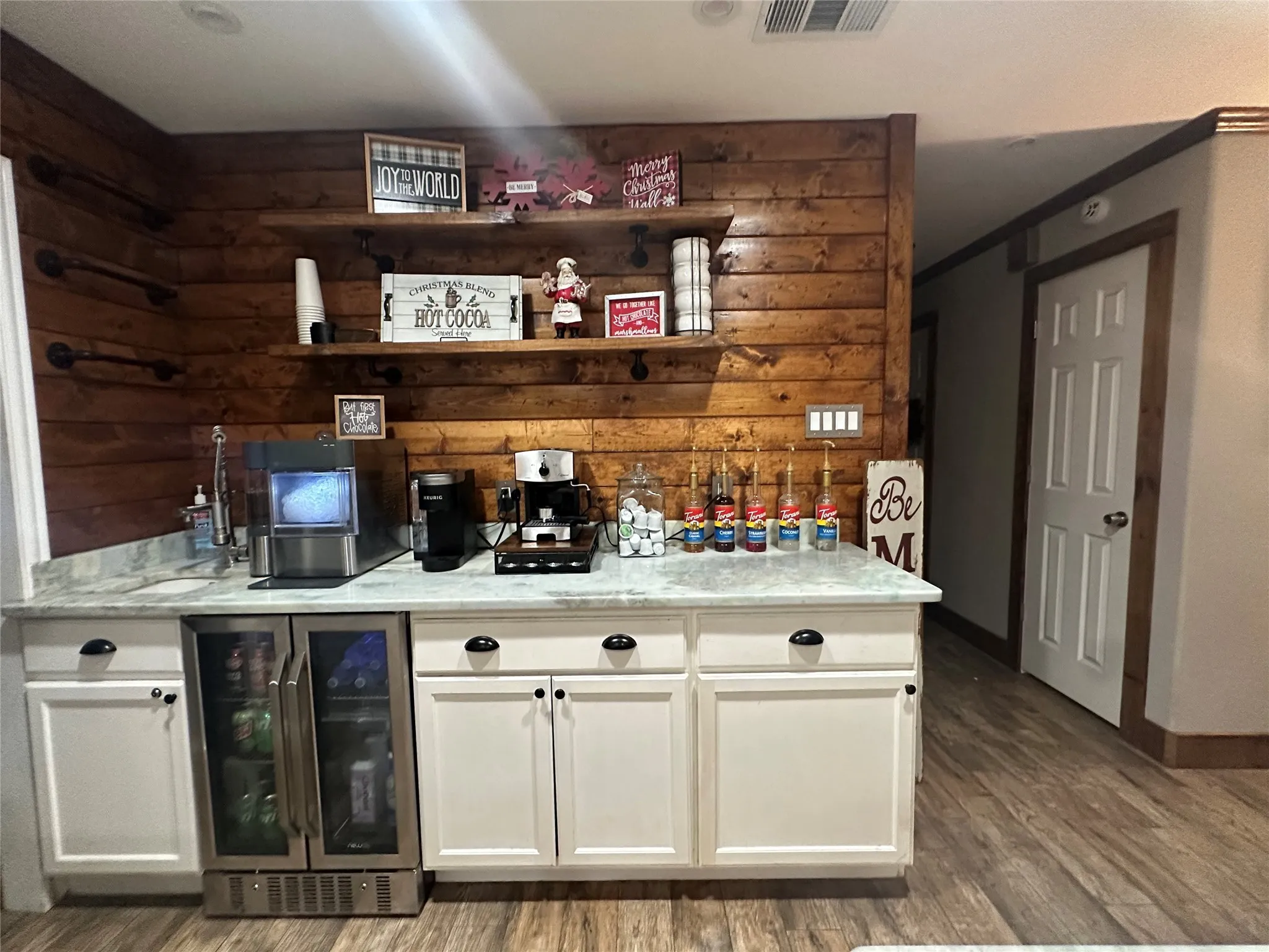 Bar with open shelves, white cabinetry, wine cooler, light wood finished floors, and wooden walls