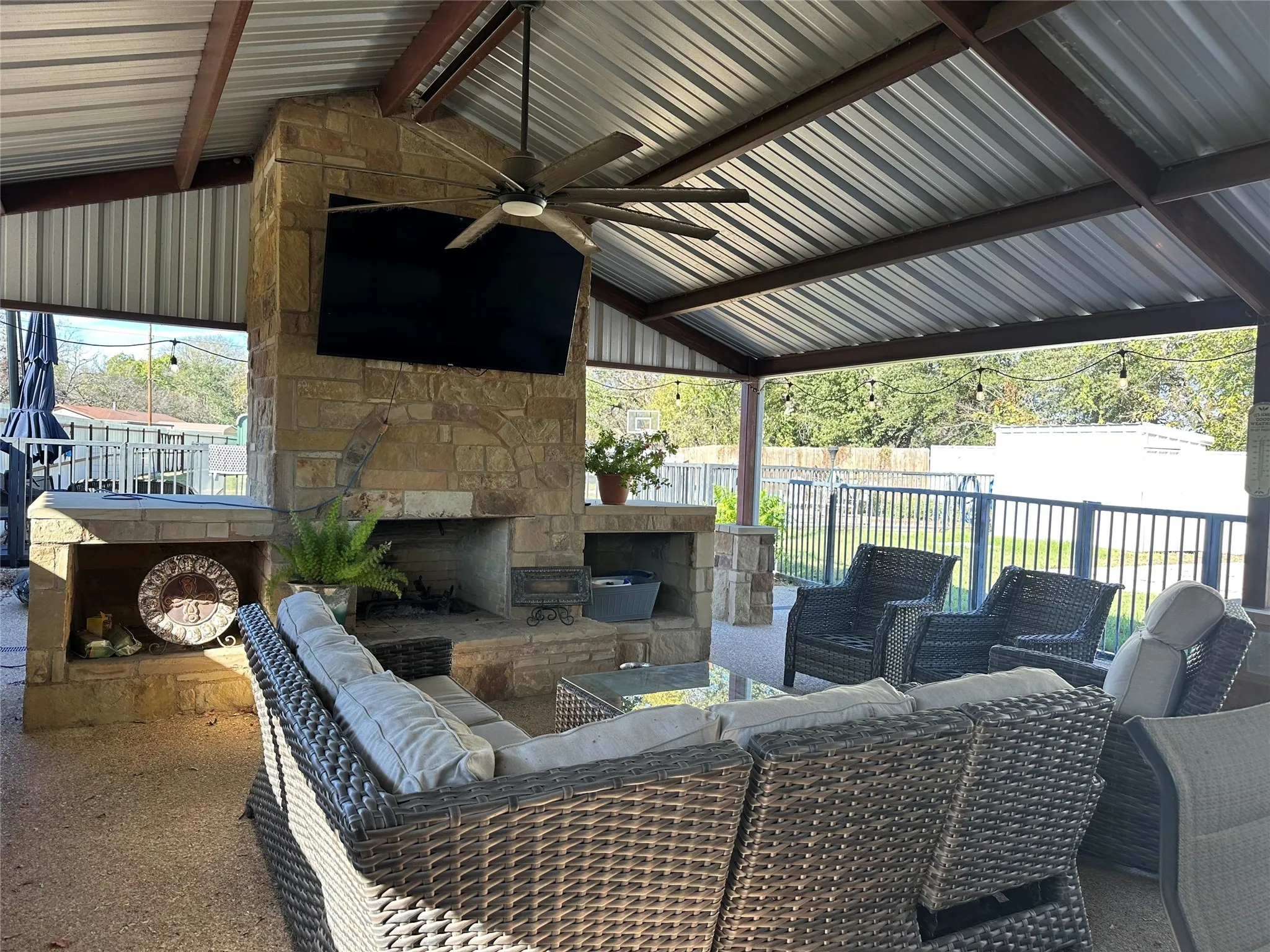 Fenced backyard with an outdoor living space, a ceiling fan, and a patio area