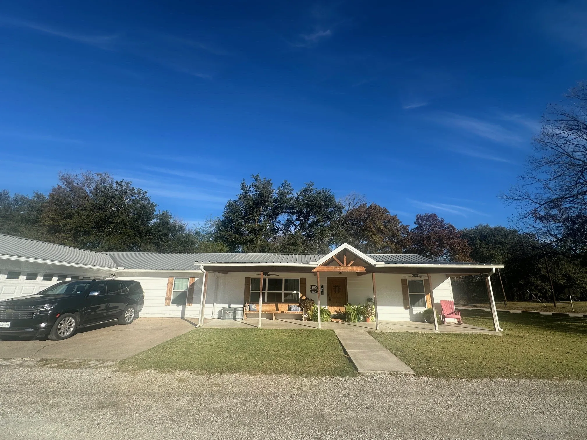 Ranch-style house with covered porch, a metal roof, and a front yard