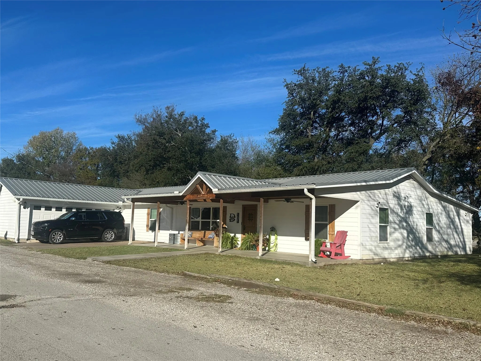 Single story home featuring a porch, a metal roof, and a front yard