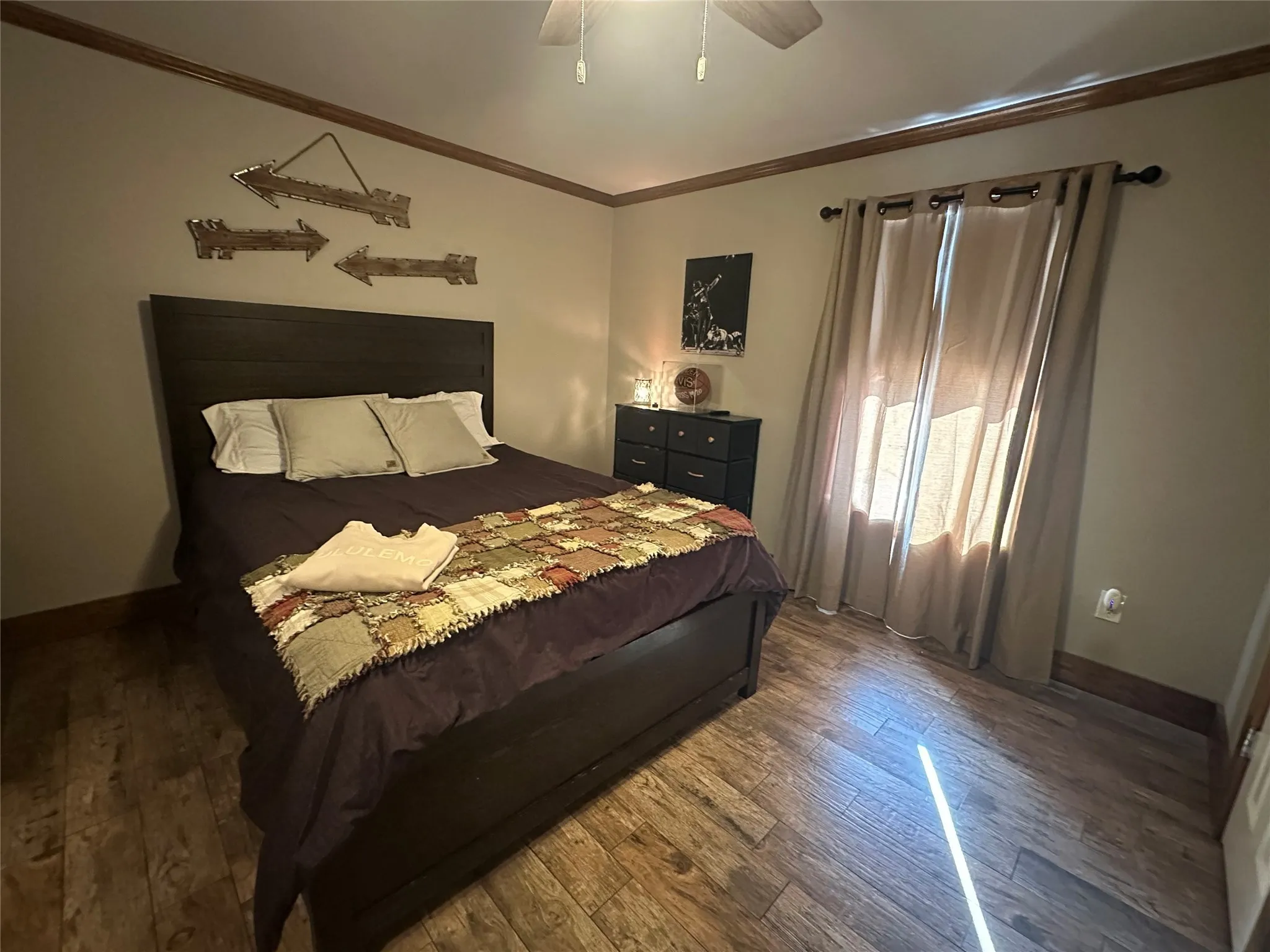 Bedroom featuring ornamental molding, hardwood / wood-style flooring, and ceiling fan