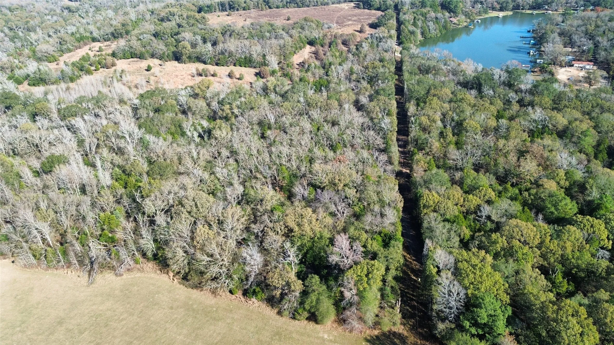 Aerial overview of property's location featuring a large body of water and a heavily wooded area