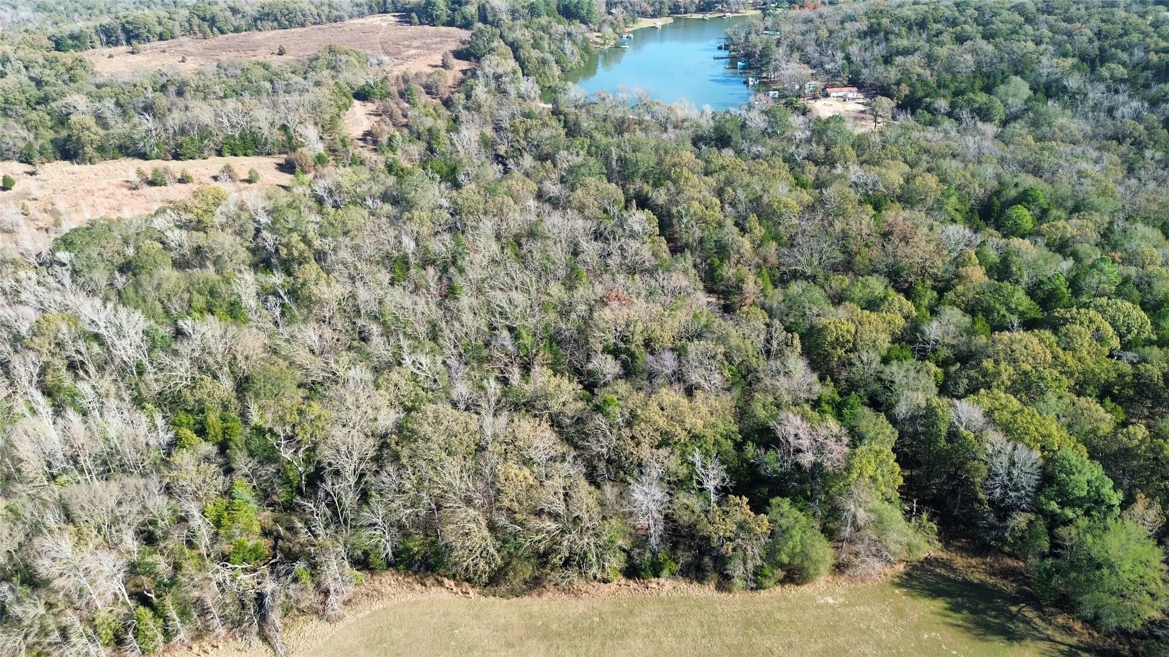 View of property location featuring a nearby body of water and a heavily wooded area