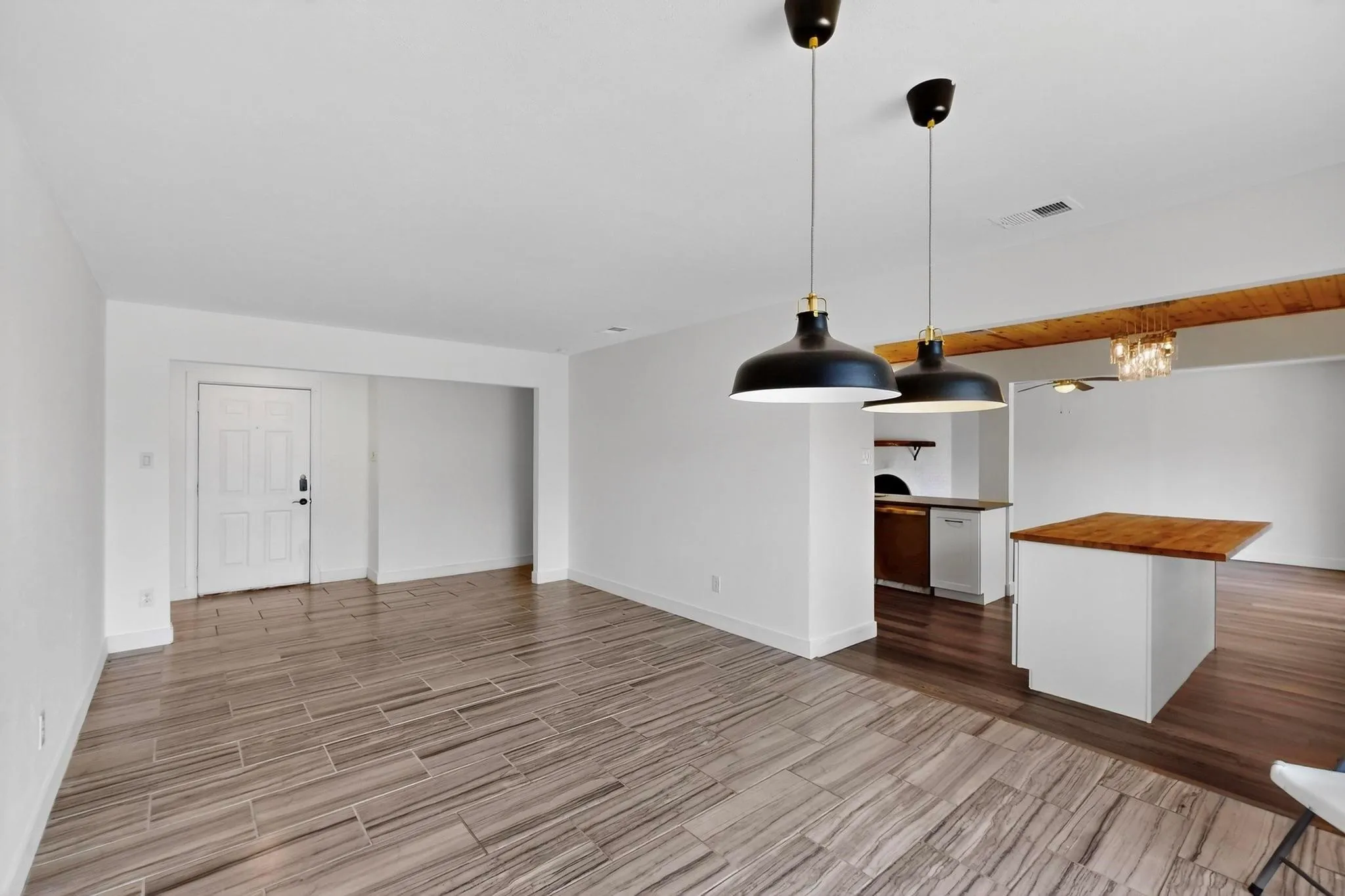 Unfurnished living room with wood tiled floors and a chandelier