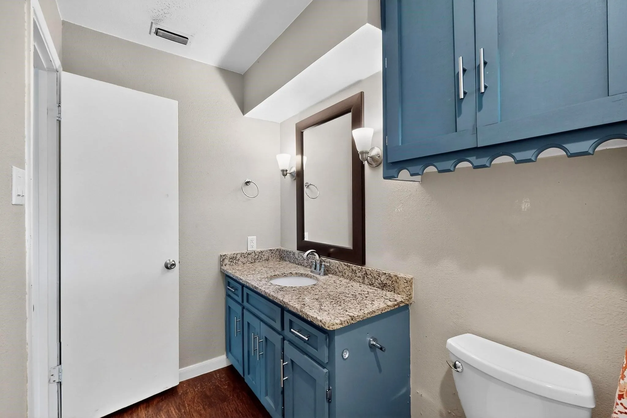 Half bath with vanity and dark wood-style floors