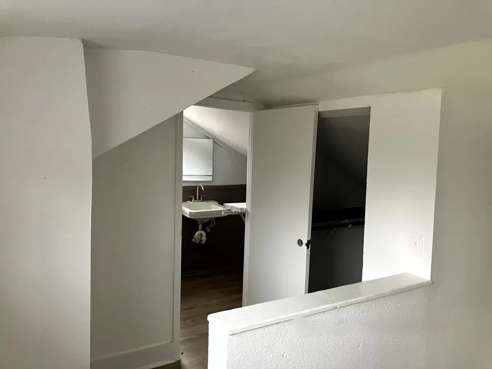 Corridor with lofted ceiling and wood finished floors