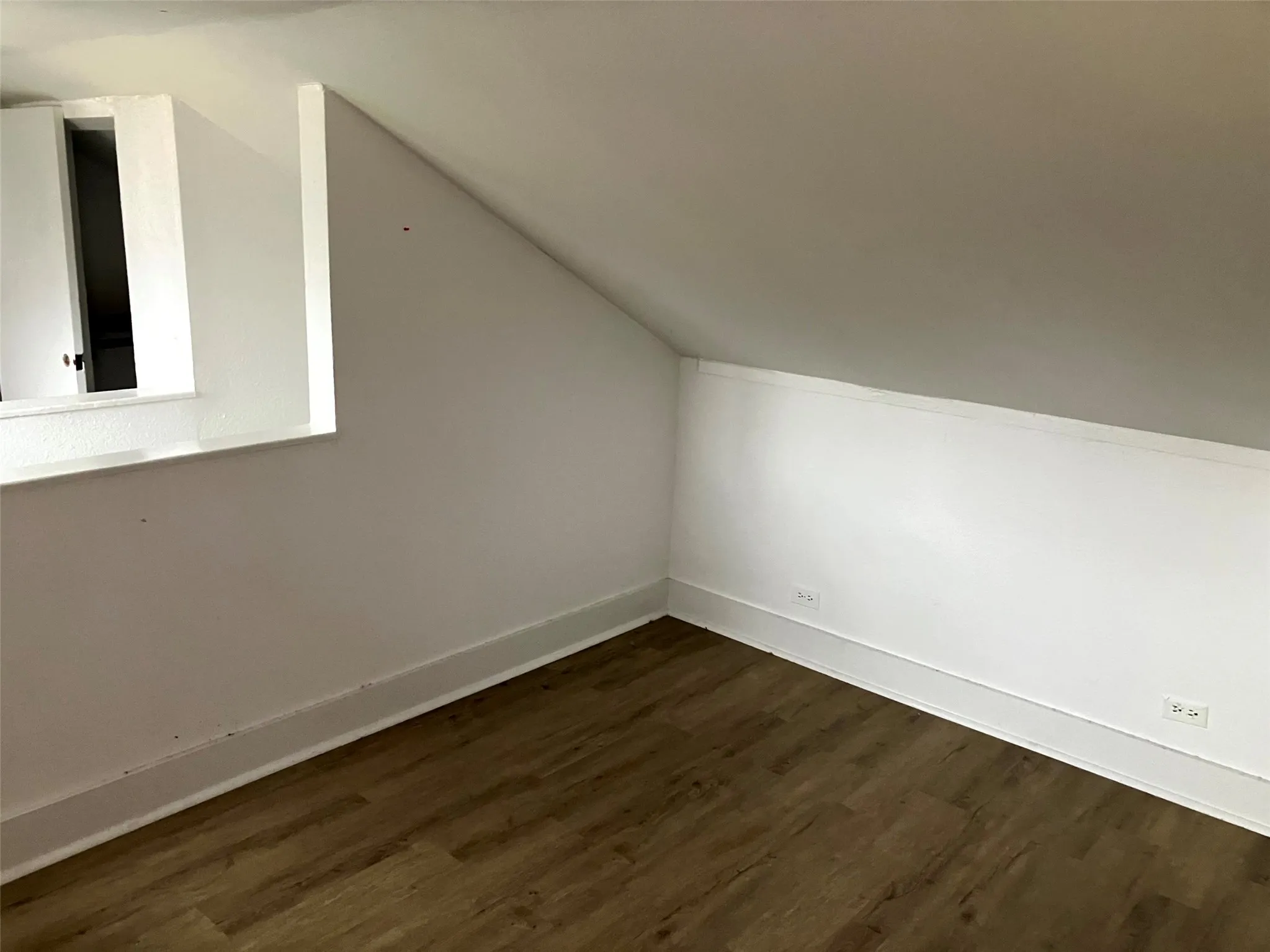 Additional living space featuring lofted ceiling and dark wood finished floors