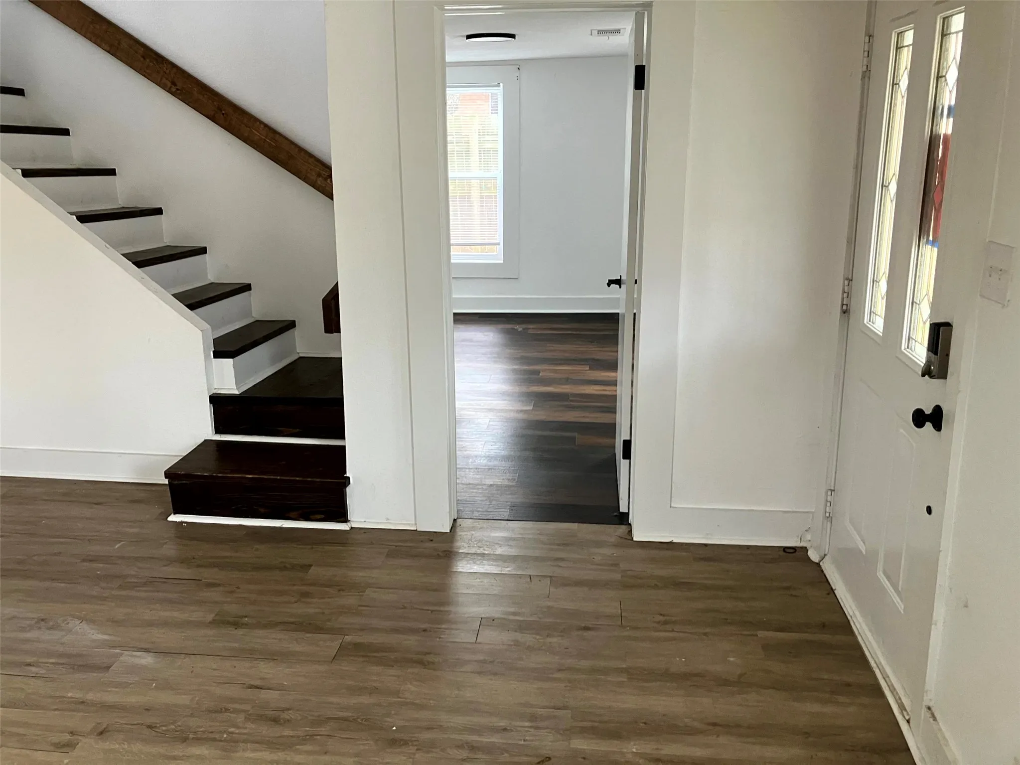 Foyer featuring dark wood-style flooring and stairway