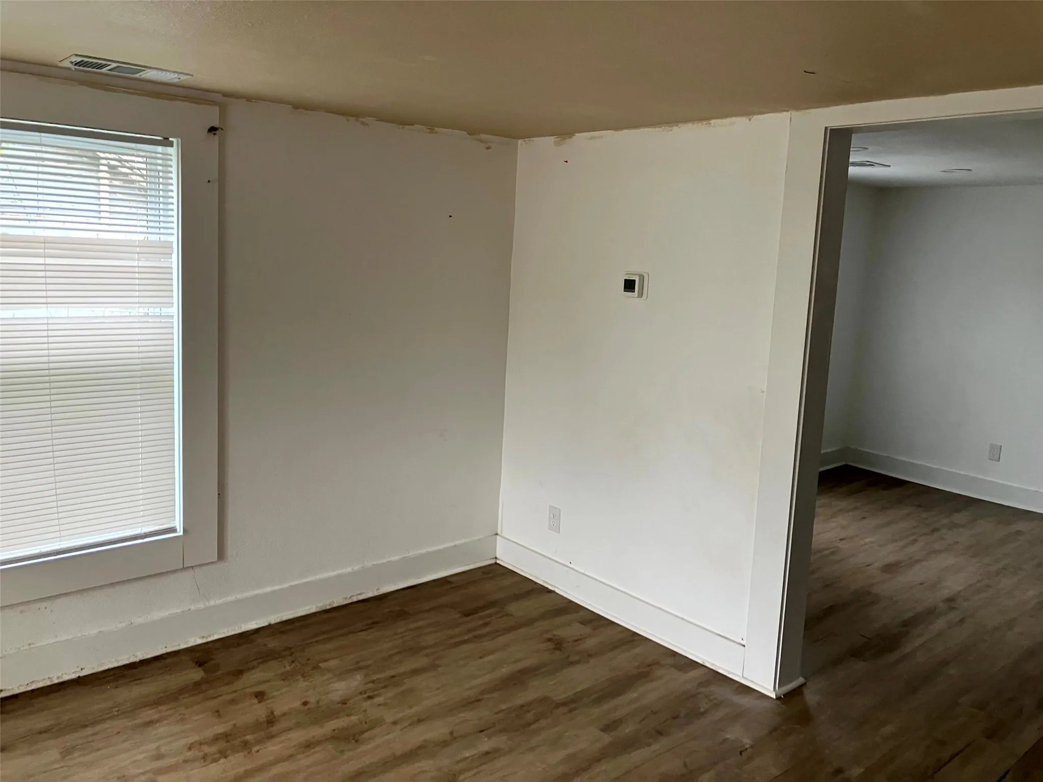 Unfurnished room featuring dark wood finished floors and baseboards