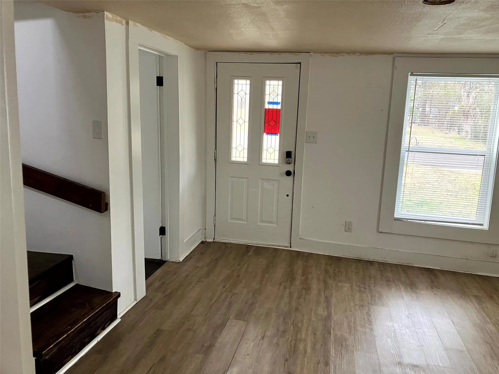 Foyer entrance featuring healthy amount of natural light, wood finished floors, and a textured ceiling