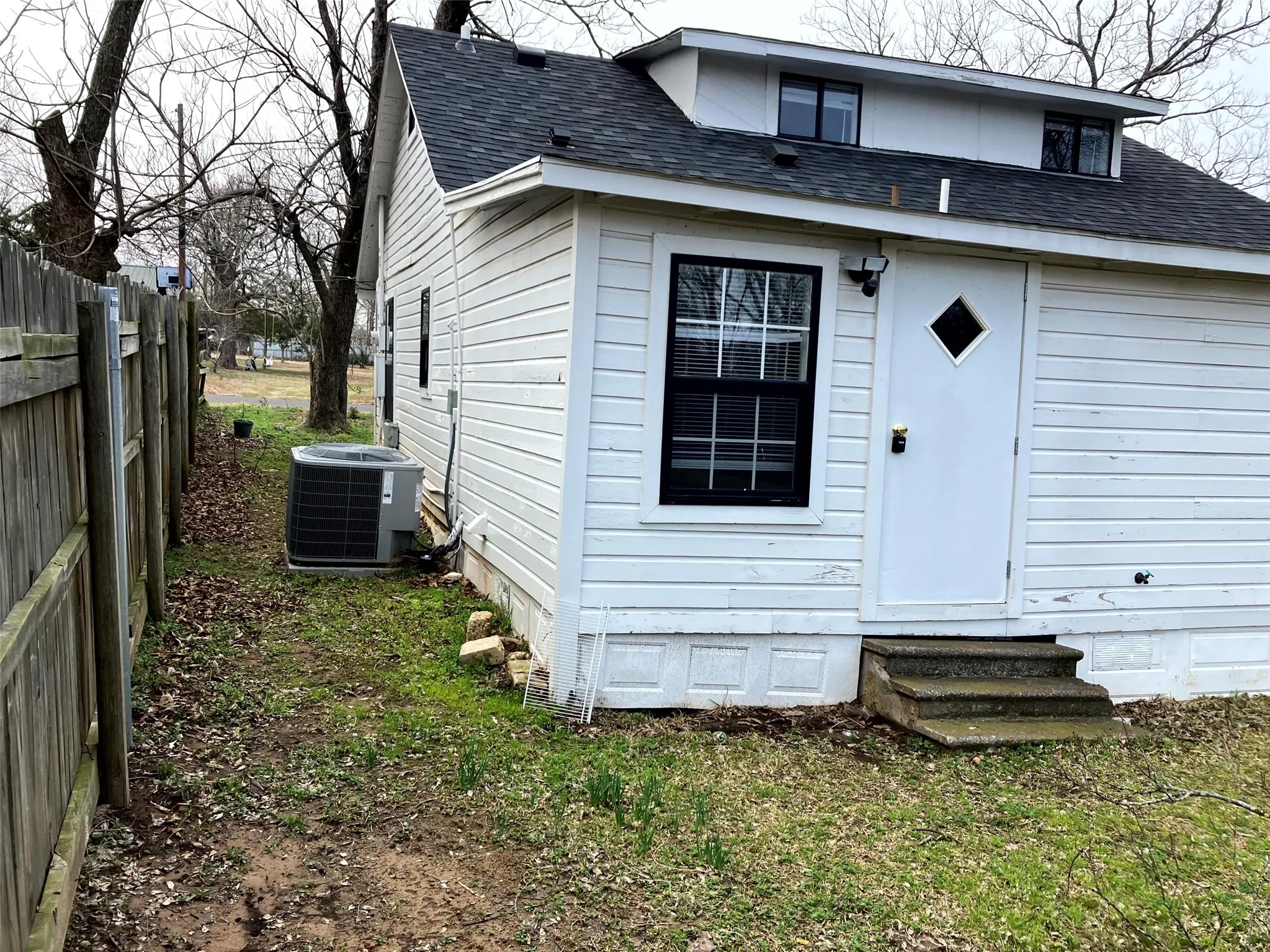 Back of property with roof with shingles, entry steps, and crawl space