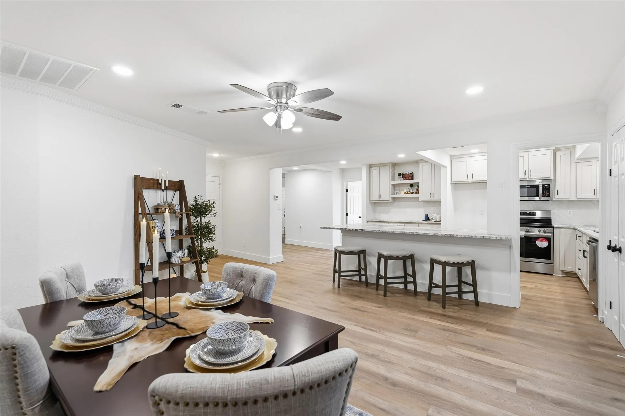 Dining room with recessed lighting, ornamental molding, light wood-style flooring, and a ceiling fan