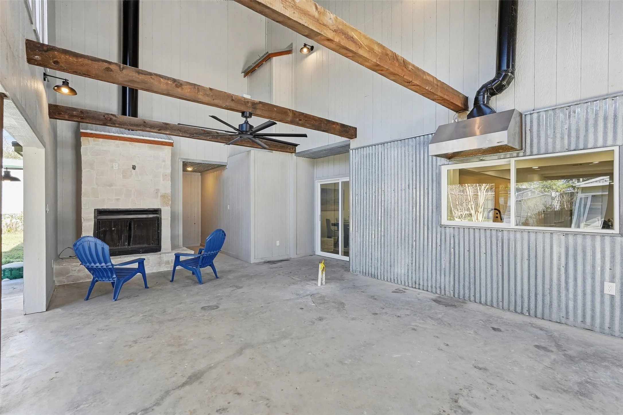 View of patio on looking fireplace and a ceiling fan