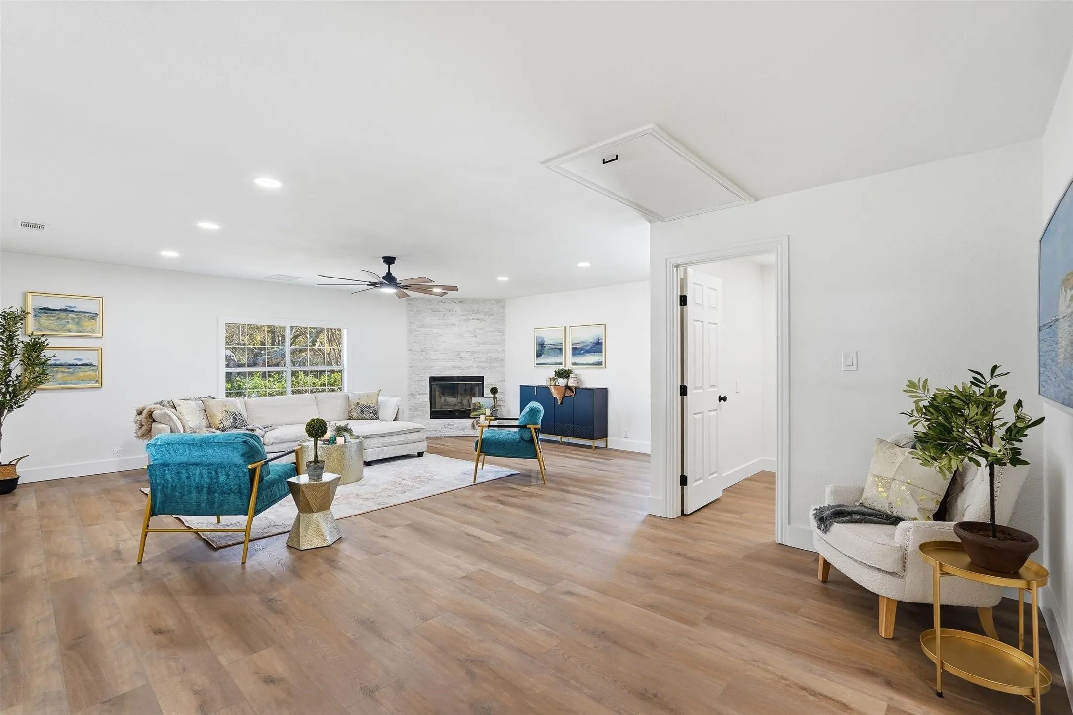 Living room with attic access, recessed lighting, light wood-style floors, ceiling fan, and a fireplace