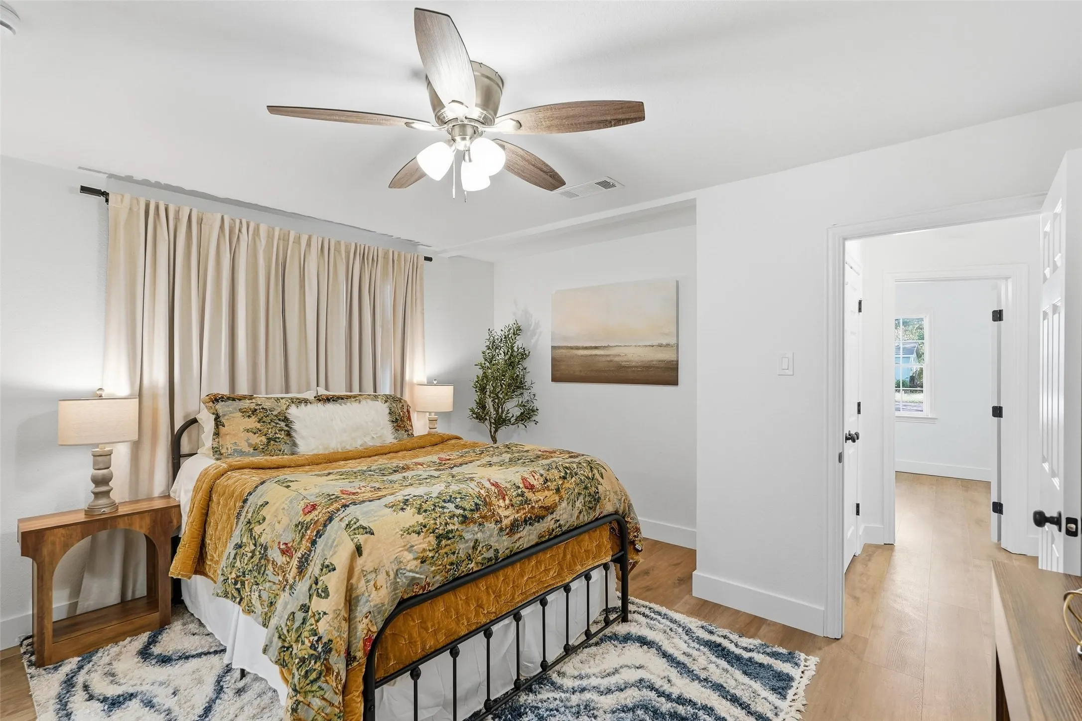 Primary bedroom featuring light wood finished floors and a ceiling fan