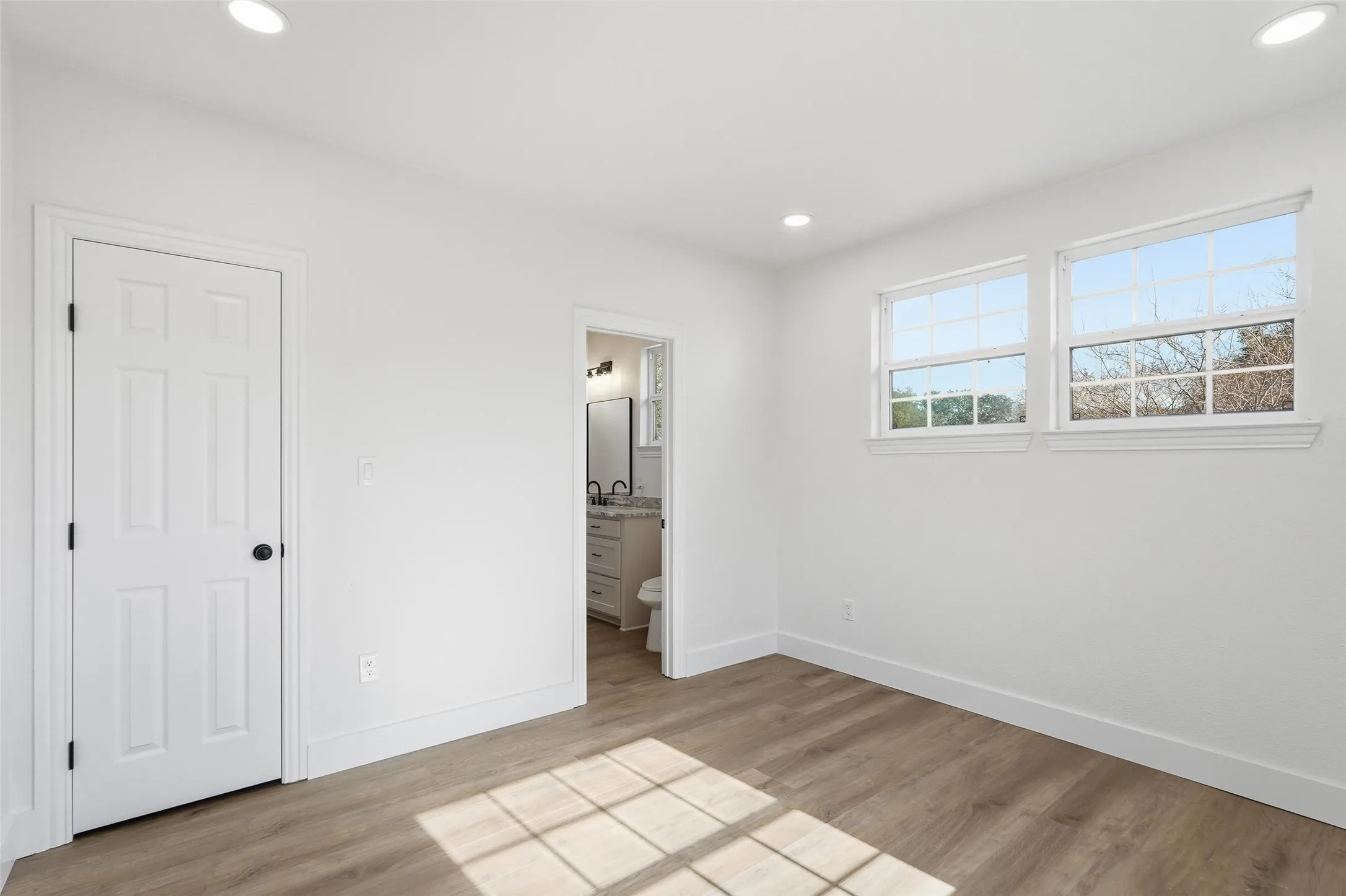 Upstairs bedroom featuring recessed lighting, light wood-style flooring, and connected bathroom