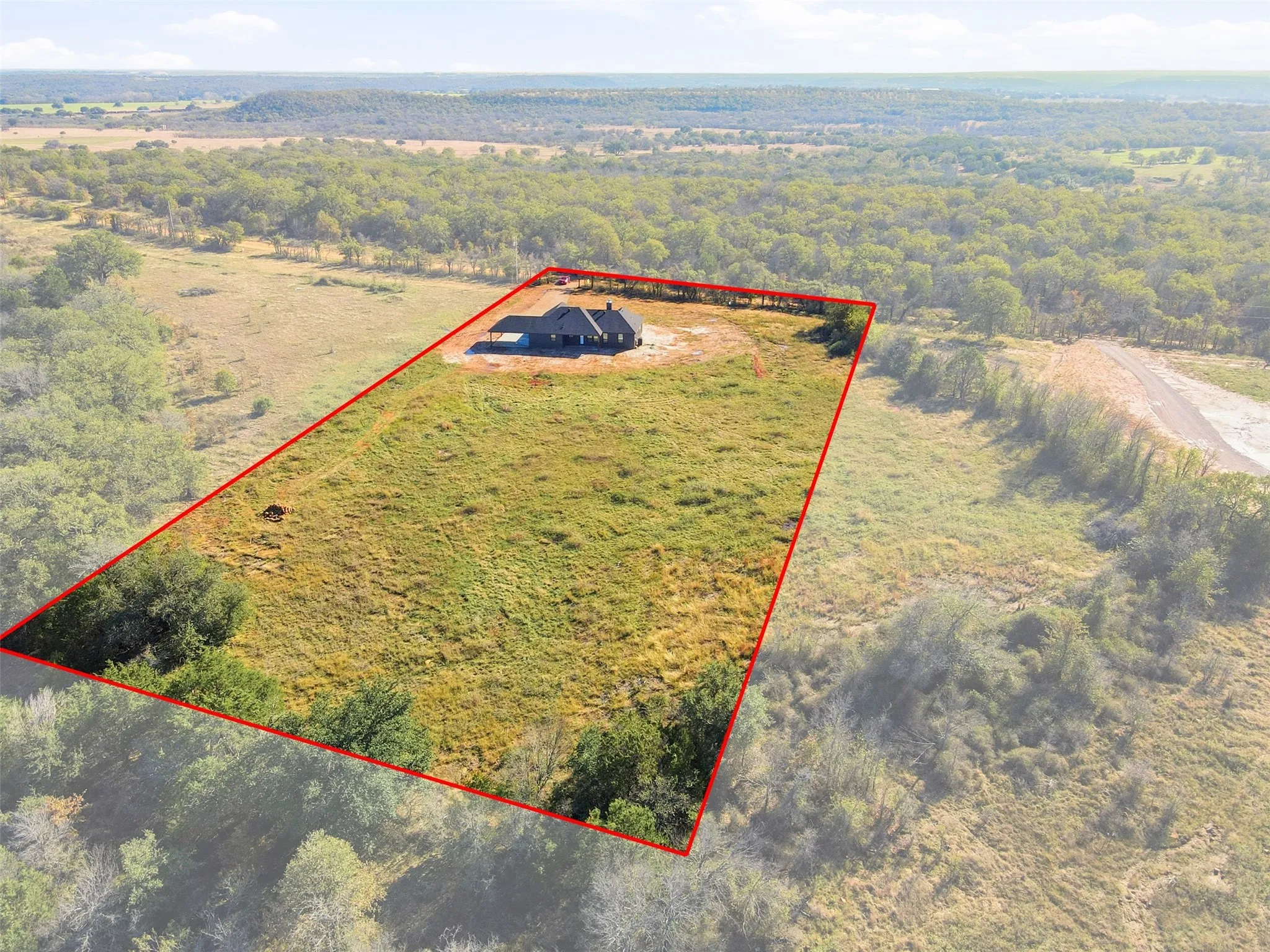 View from above of property with a heavily wooded area and property boundaries highlighted