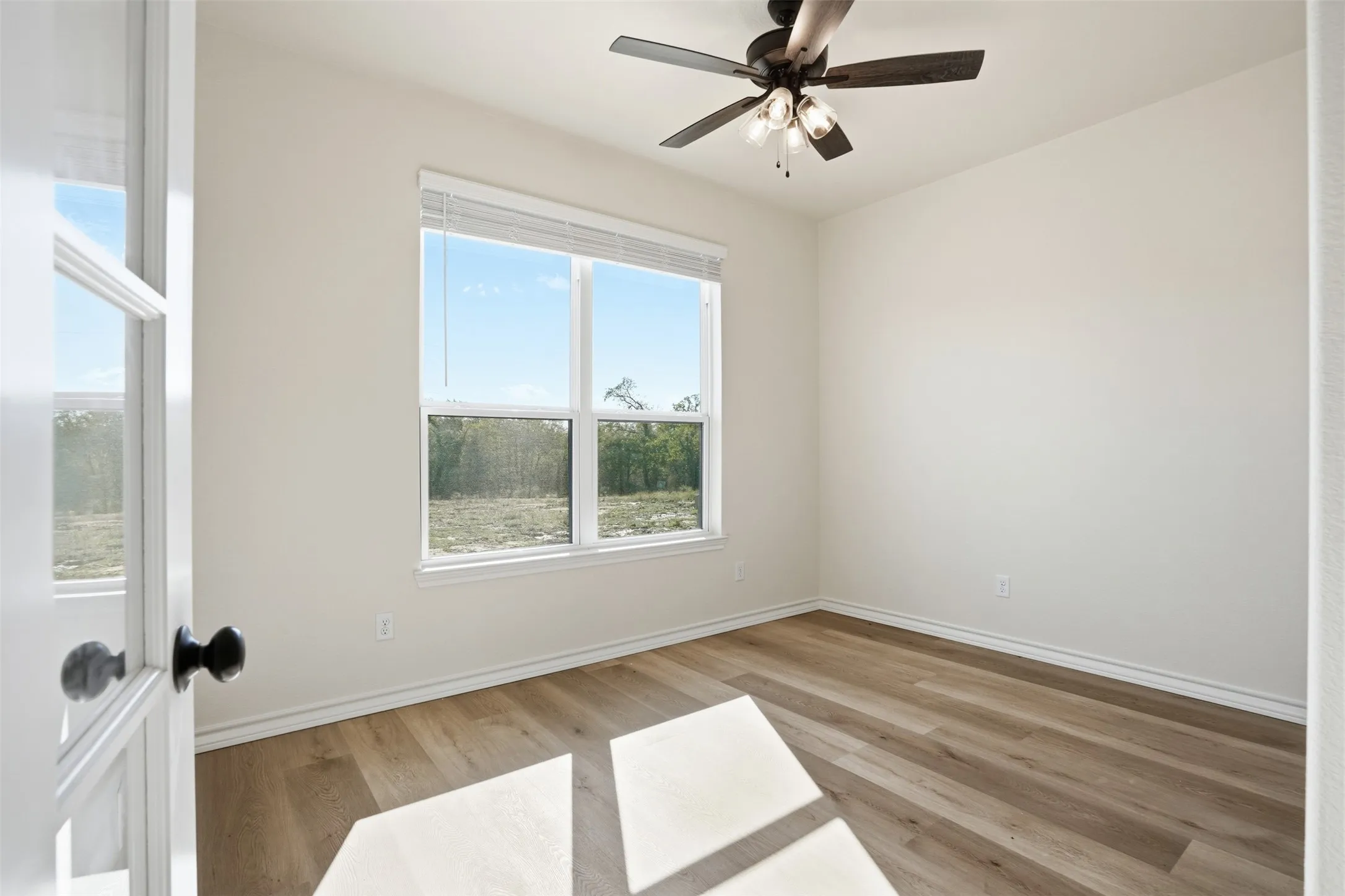 Unfurnished room featuring light wood finished floors and a ceiling fan