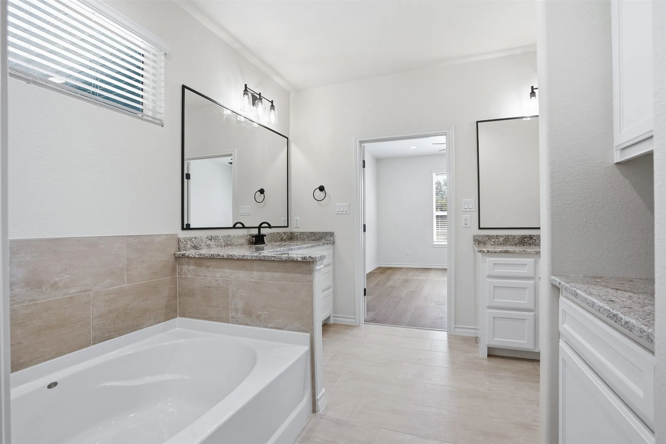 Full bathroom with vanity and a garden tub
