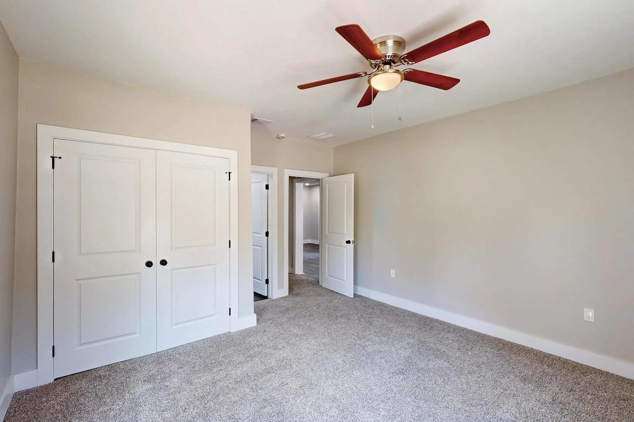 Unfurnished bedroom featuring light colored carpet, a ceiling fan, and a closet