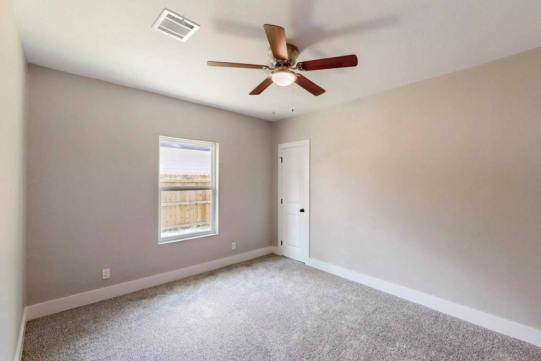 Spare room with carpet and a ceiling fan