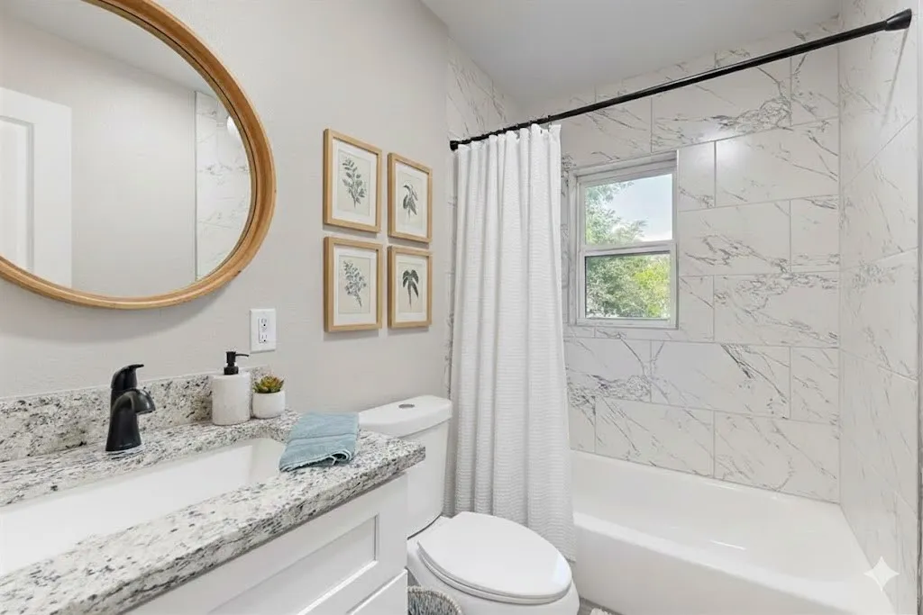 Full bath featuring shower / tub combo and vanity