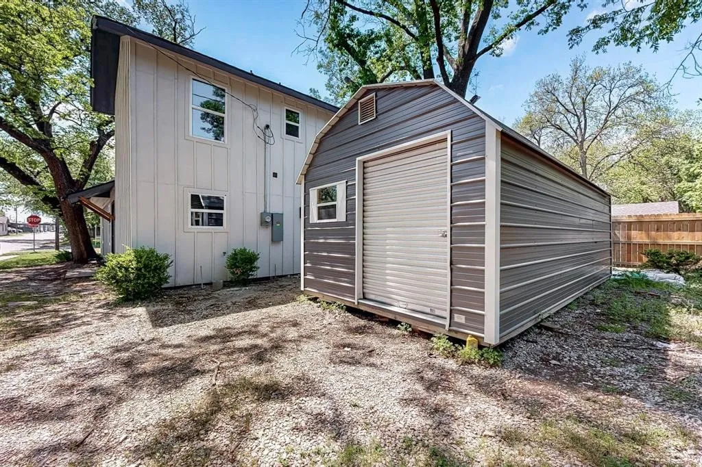 Back of house with board and batten siding and a shed