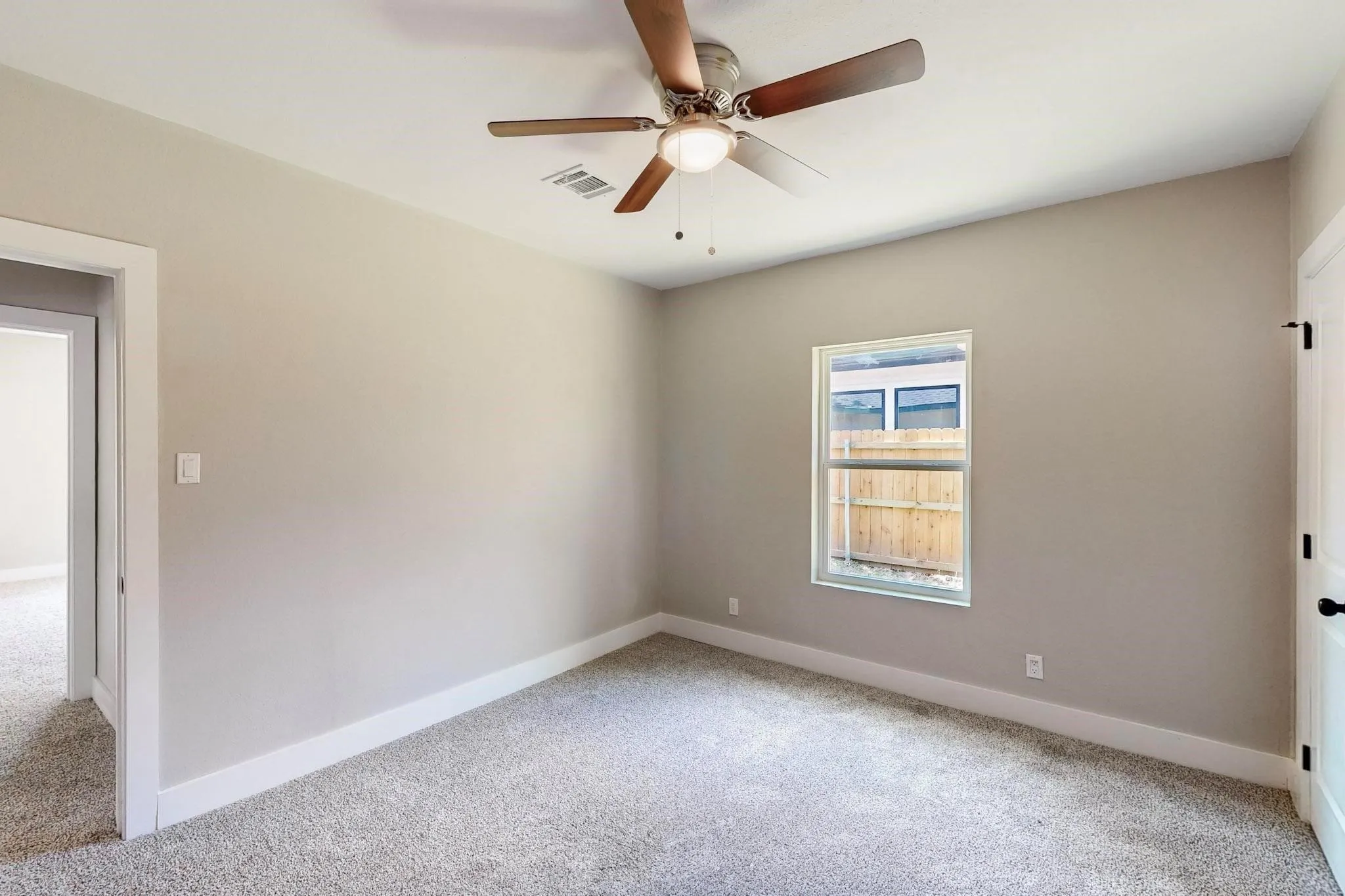 Spare room featuring light colored carpet and a ceiling fan