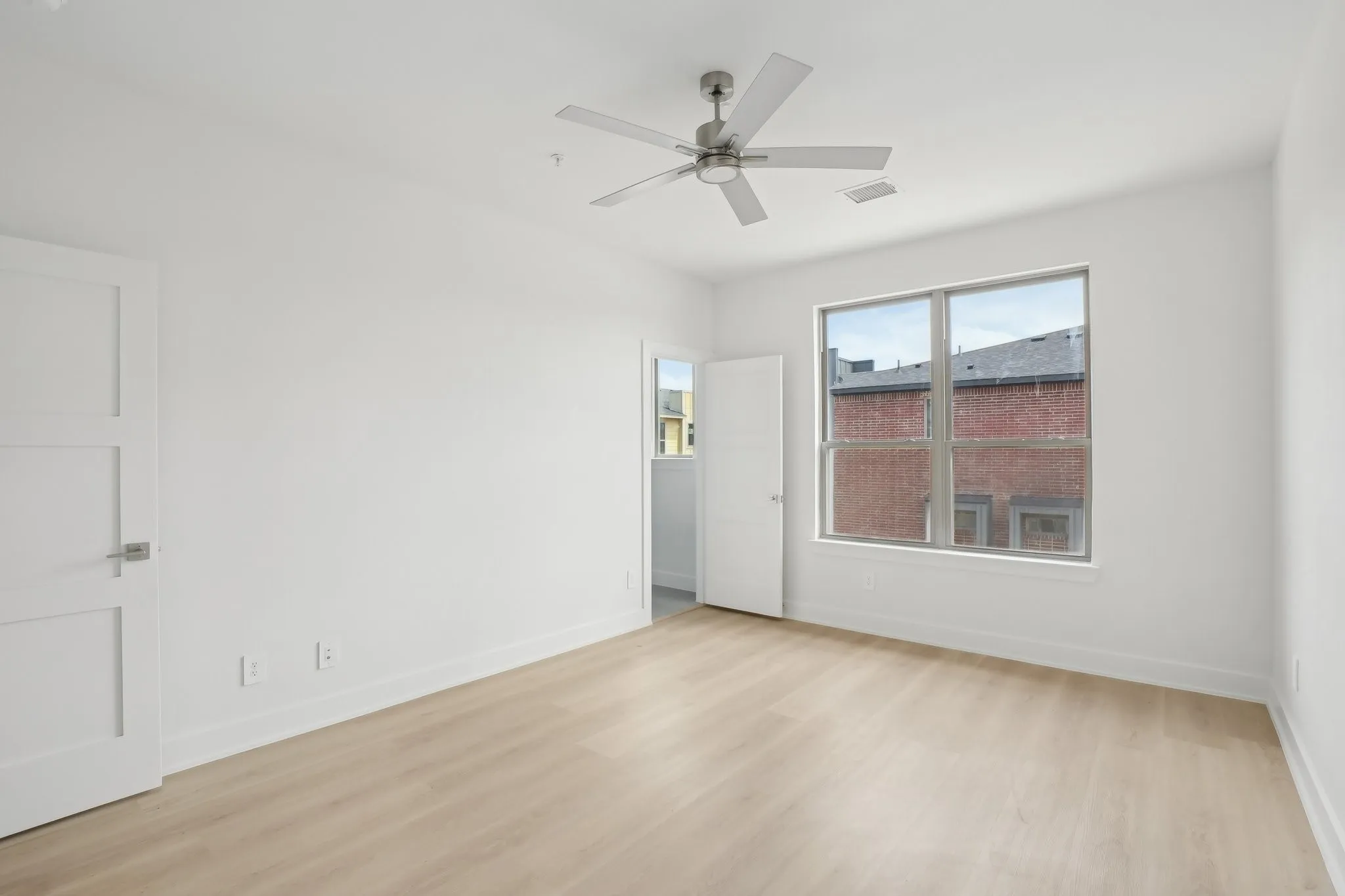Empty room featuring light wood-style floors and a ceiling fan