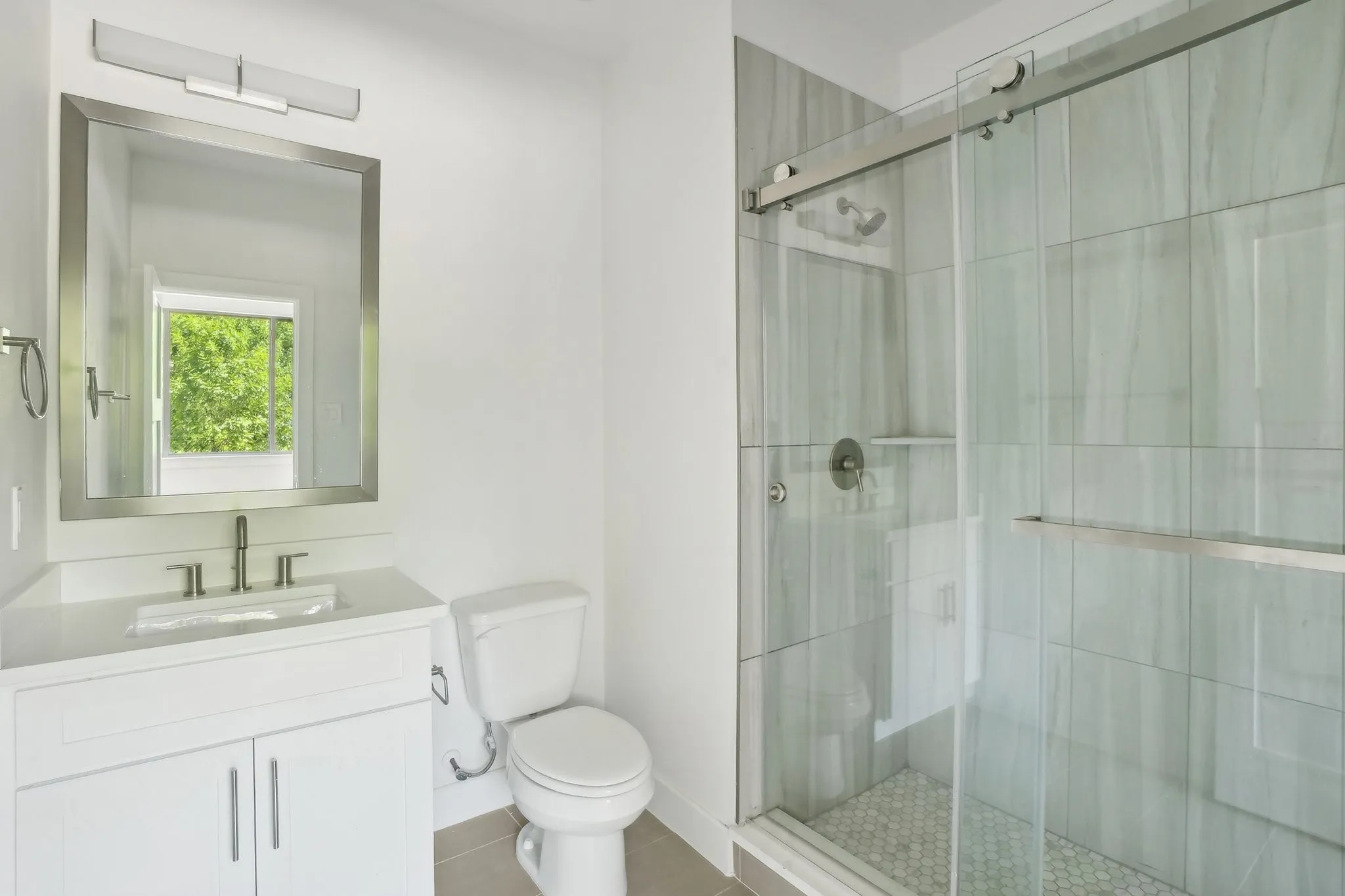 Bathroom with vanity, a shower stall, and light tile patterned floors