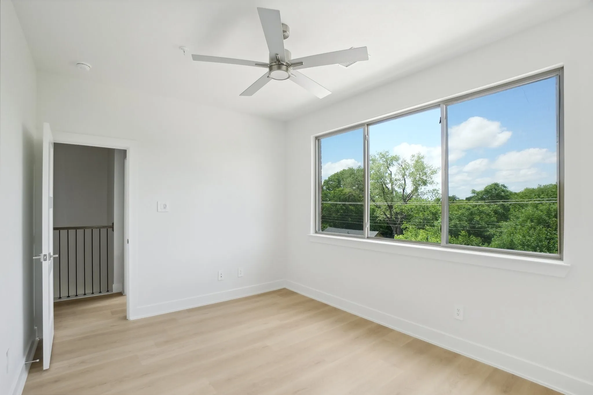 Unfurnished room with light wood-style floors and a ceiling fan
